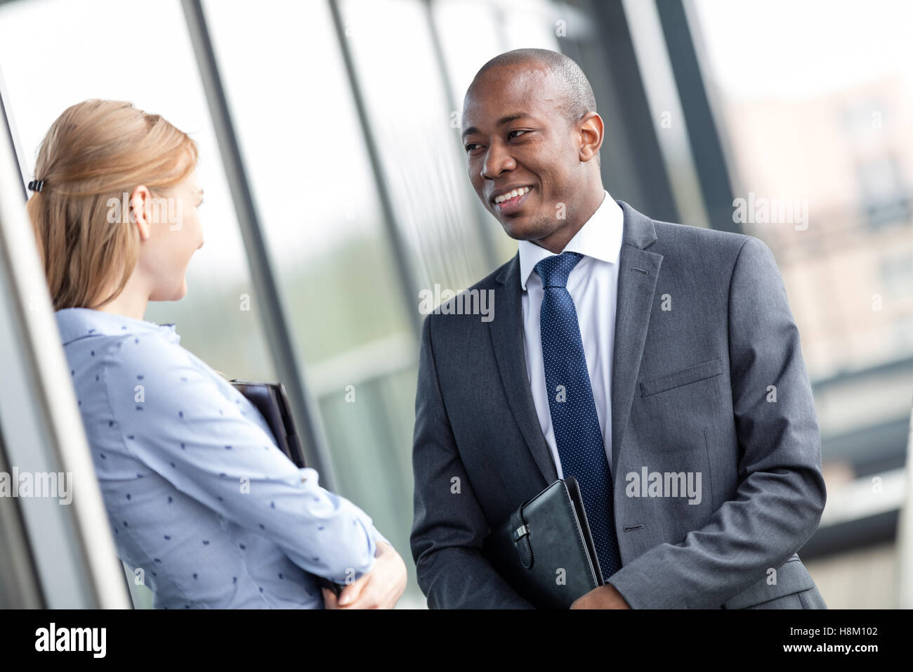 Lächelnd jungen Geschäftsmann mit Kollegin im Büro Balkon Stockfoto
