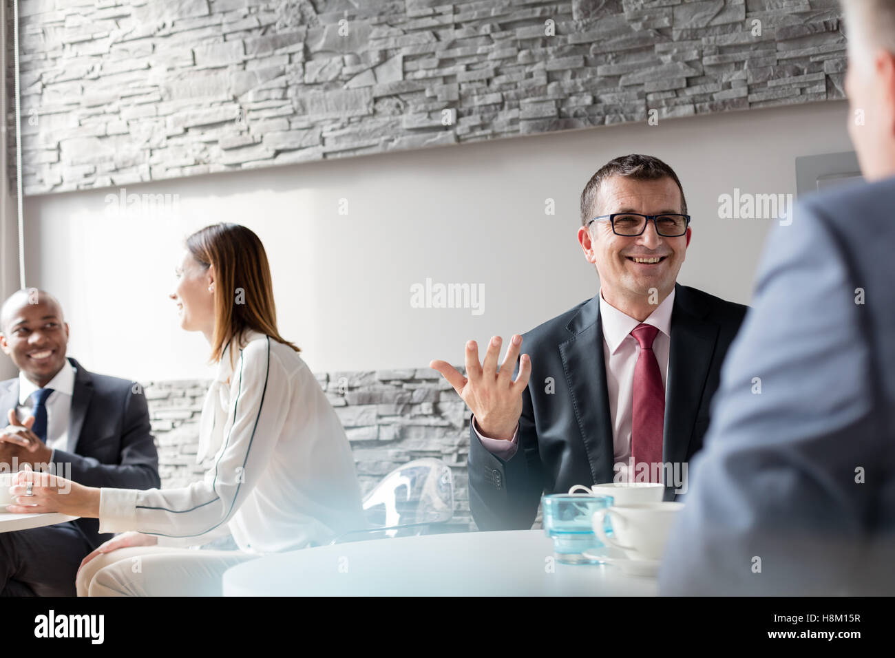Reifen Mann im Gespräch mit Kollegen im Büro Cafeteria lächelnd Stockfoto