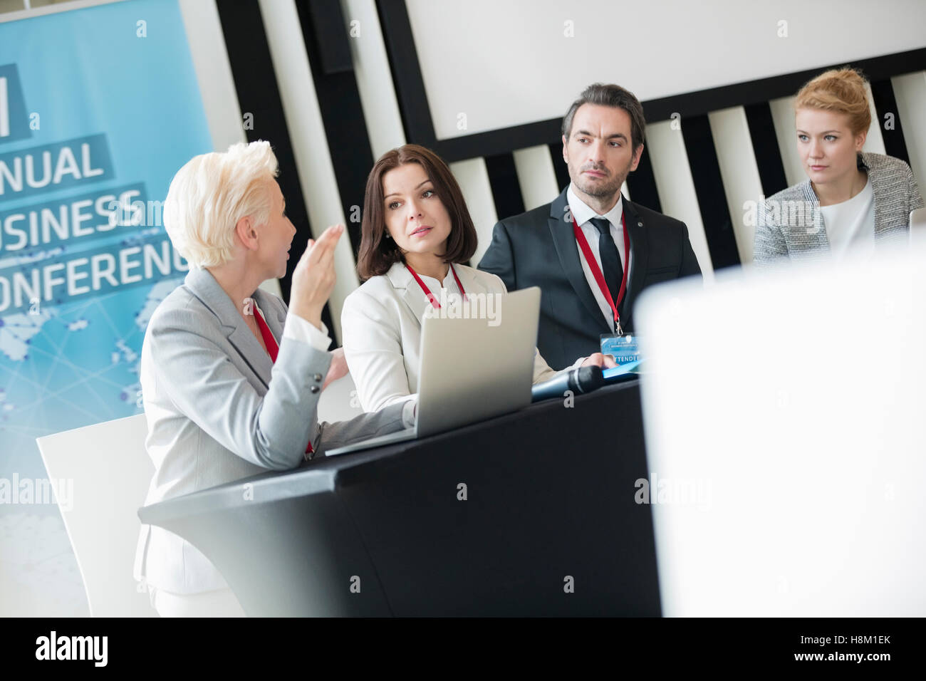 Business-Leute reden beim Sitzen am Schreibtisch im Seminarraum Stockfoto