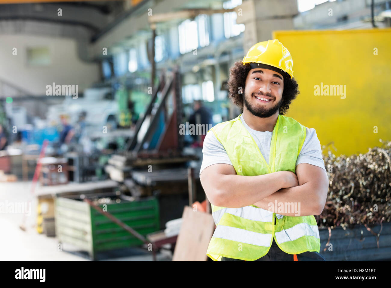 Porträt des Lächelns männliche Arbeiter stehend Arme gekreuzt in der Metallbranche Stockfoto