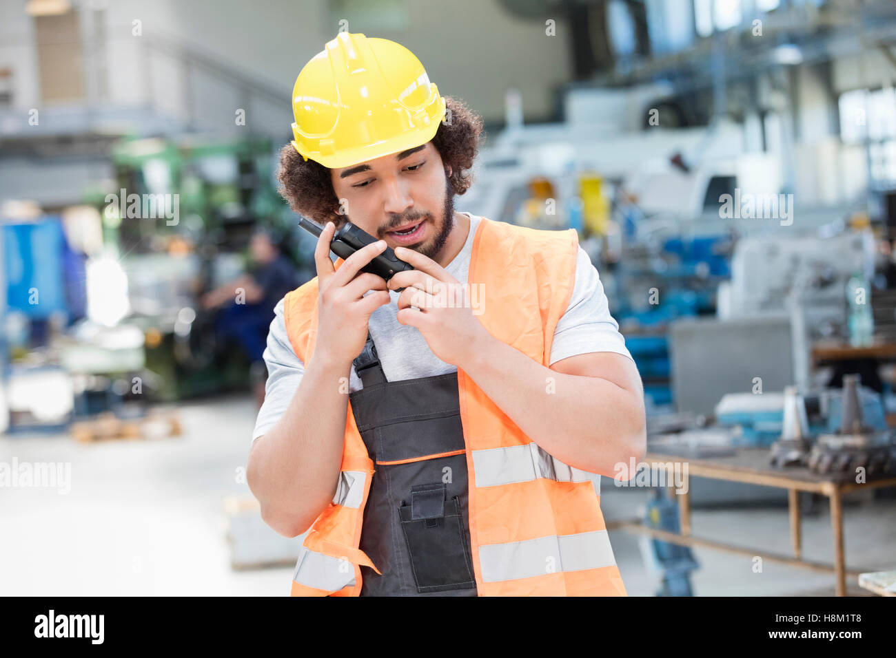Junge Arbeiter tragen von Schutzkleidung mit Walkie-talkie in der Metallbranche Stockfoto
