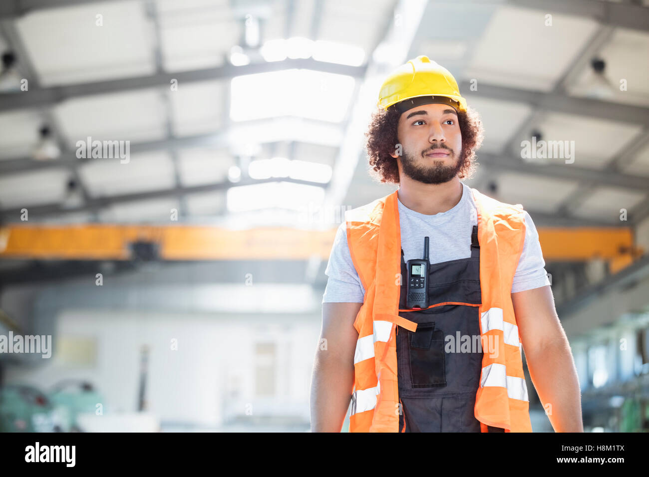 Junge Arbeiter tragen Schutzkleidung wegsehen in der Metallbranche Stockfoto