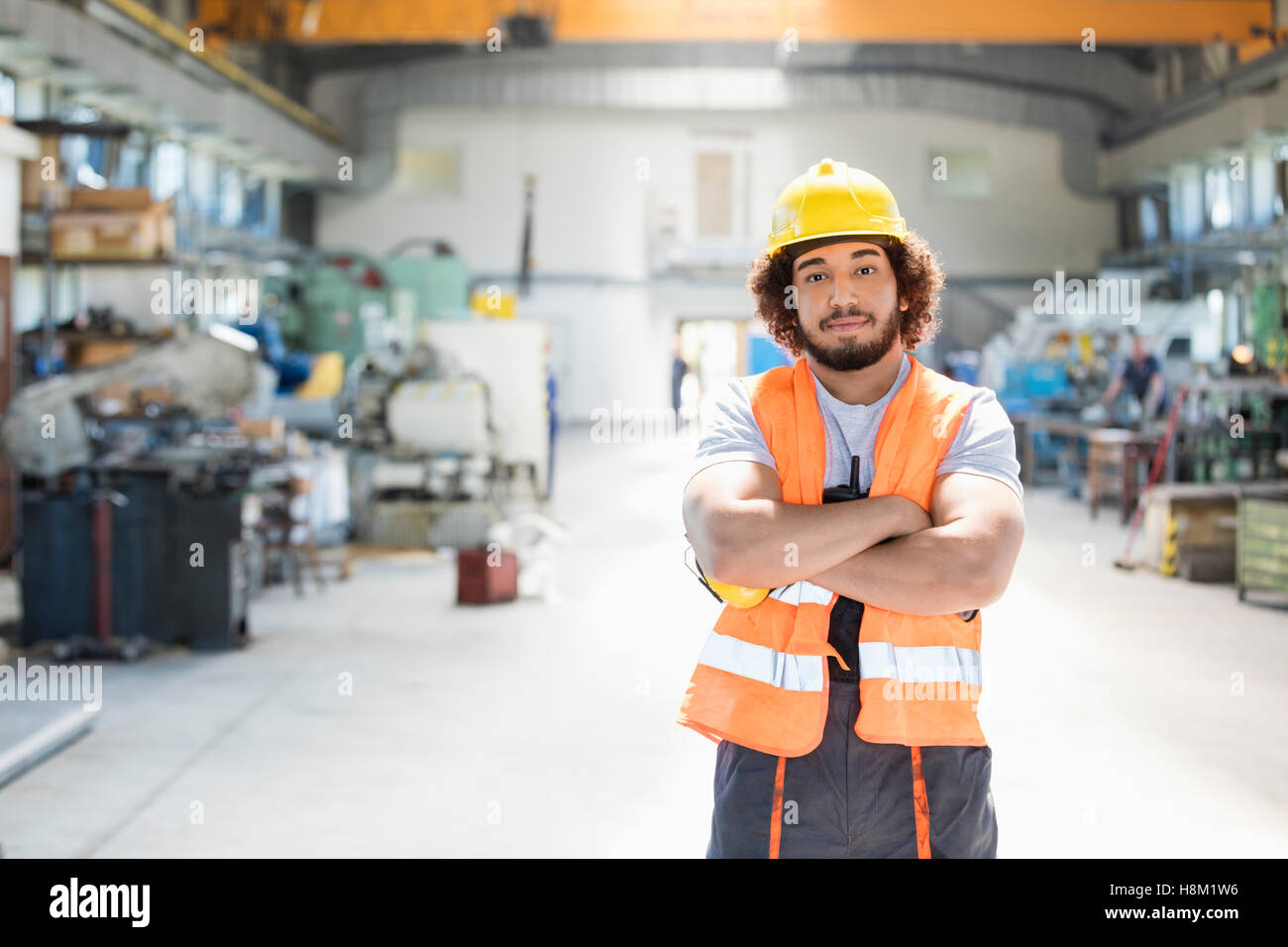 Porträt der jungen Arbeiter stehend Arme gekreuzt in Fabrik Stockfoto