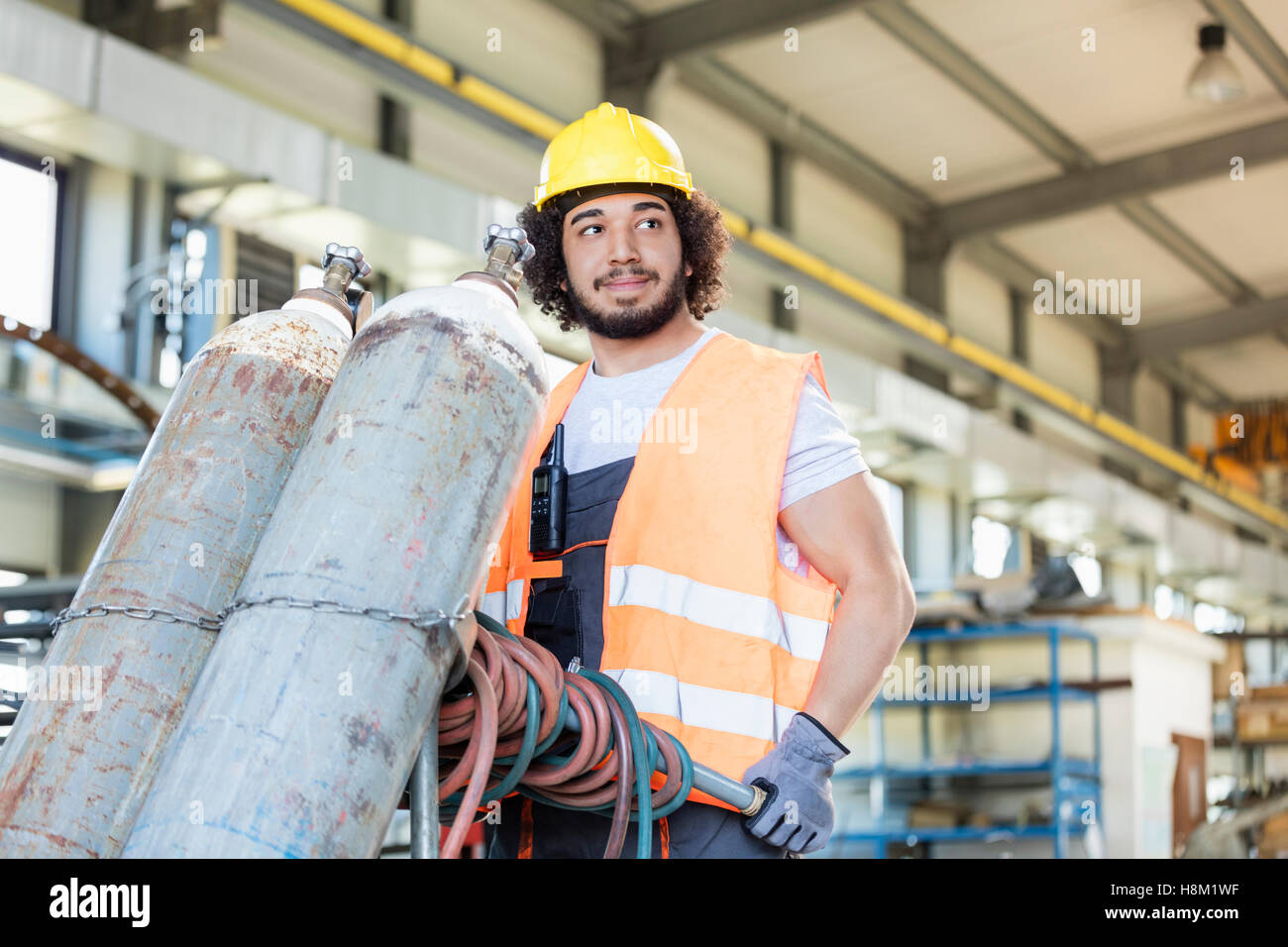 Junge Arbeiter Bewegung Gasflaschen in der Metallbranche Stockfoto