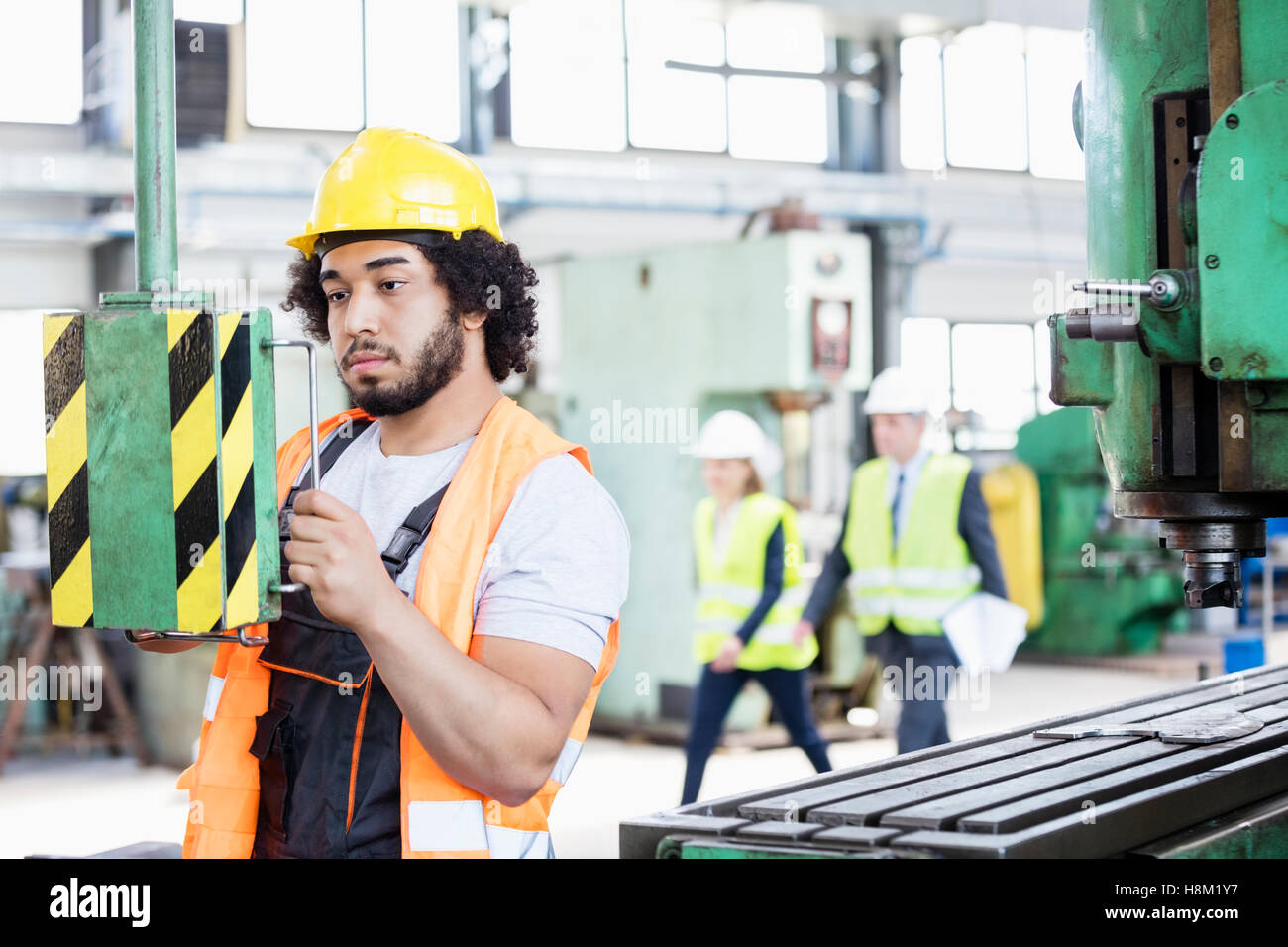 Junge Arbeiter, die Bedienung von Maschinen in der Metallbranche Stockfoto