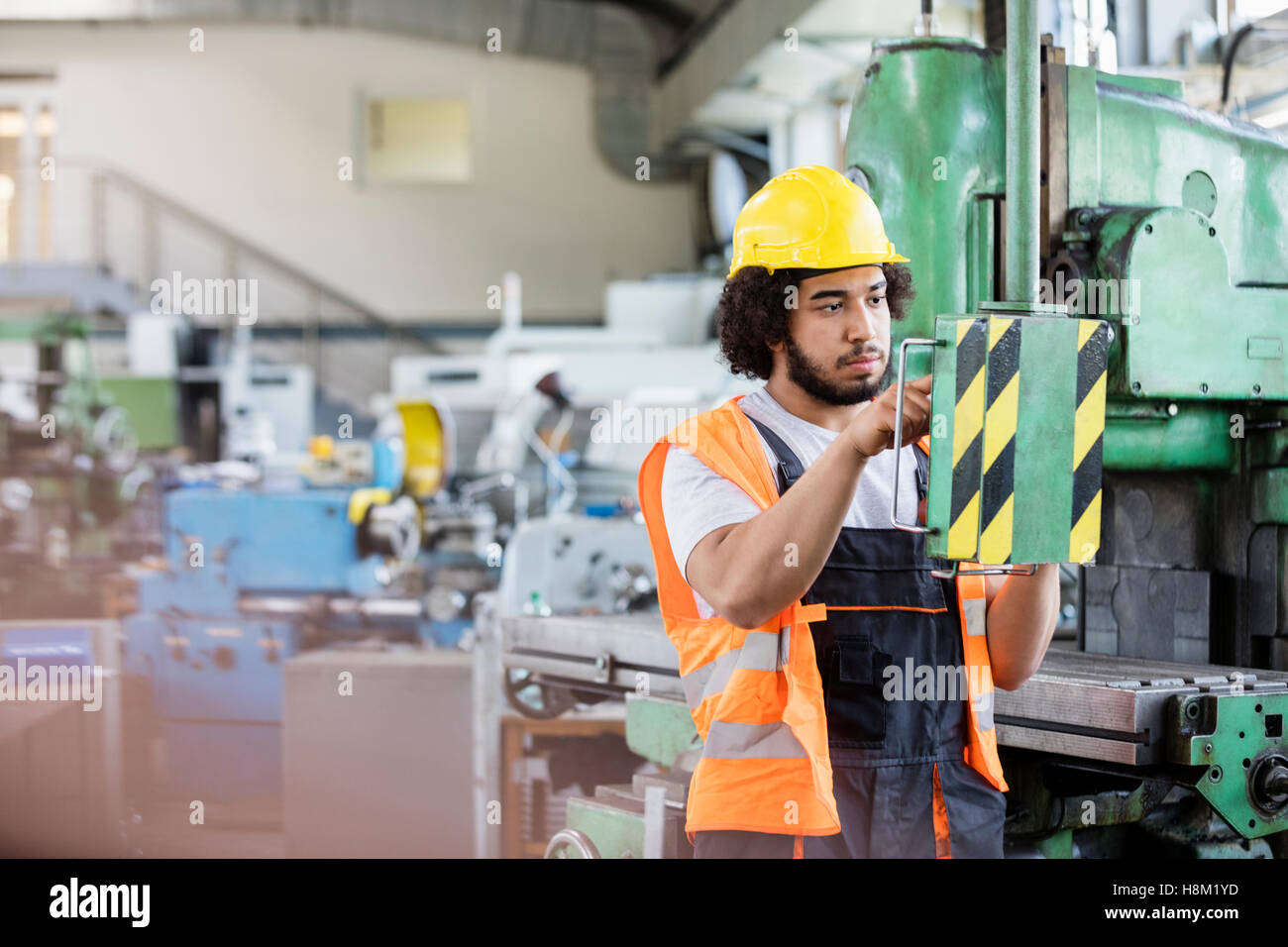 Junge Arbeiter, die Bedienung von Maschinen in der Metallbranche Stockfoto