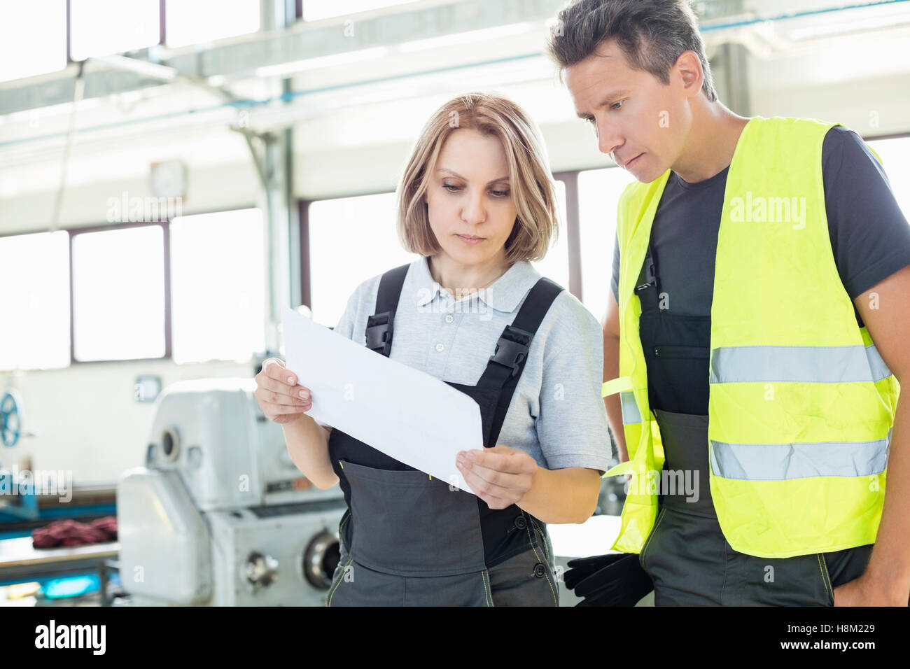 Männliche und weibliche Arbeiter Prüfung Papier in der Industrie Stockfoto