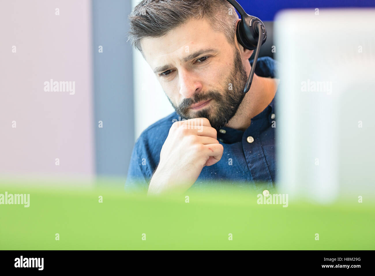 Nachdenklich Mitte adult Geschäftsmann tragen Kopfhörer im Büro Stockfoto