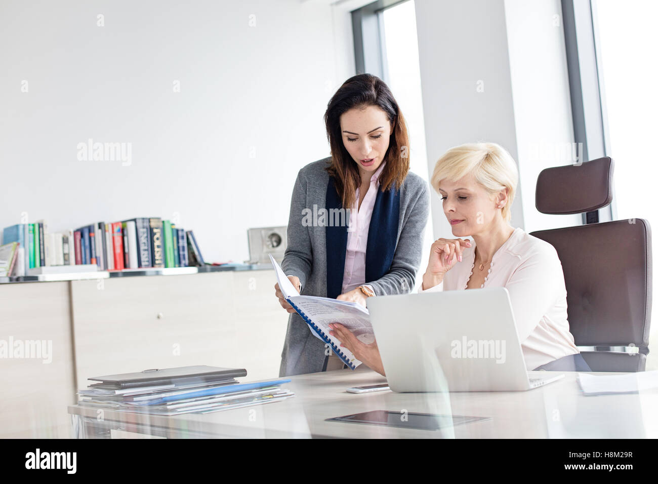 Geschäftsfrauen Buch am Schreibtisch im Büro Stockfoto