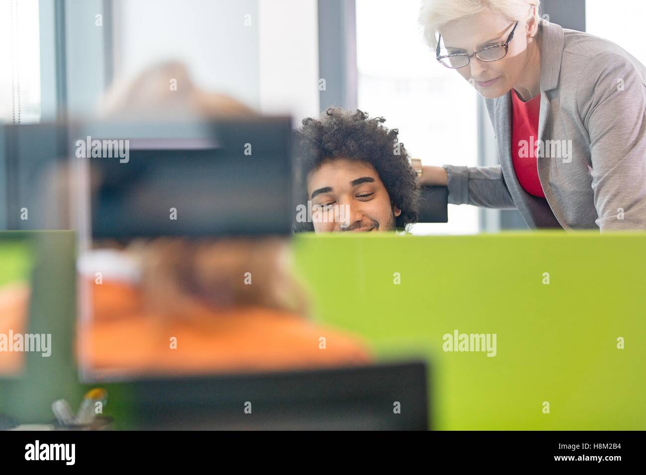Reife Geschäftsfrau mit männlichen Kollegen im Büro arbeiten Stockfoto