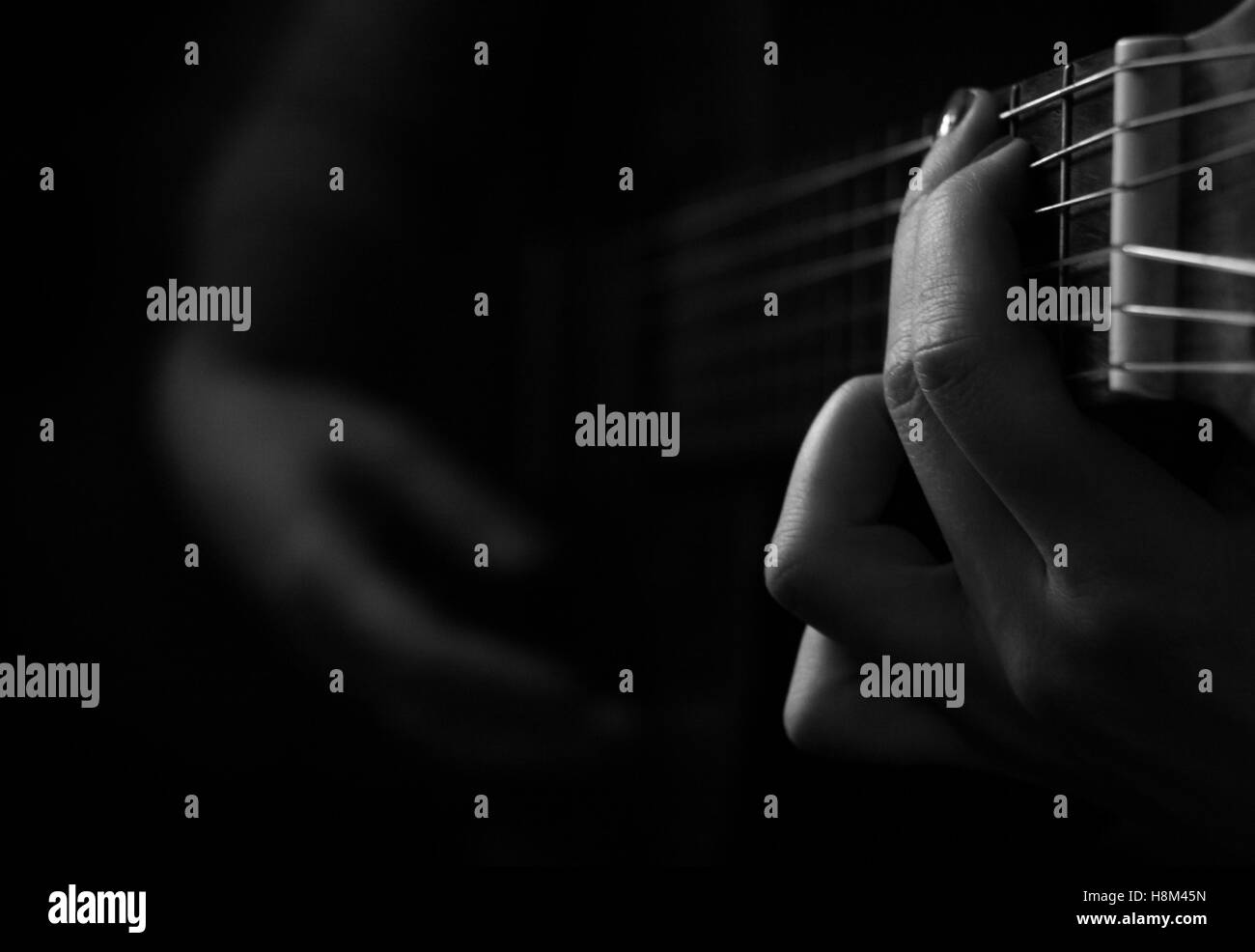 Frau Hände klassische Gitarre spielen im Dunkeln Stockfoto