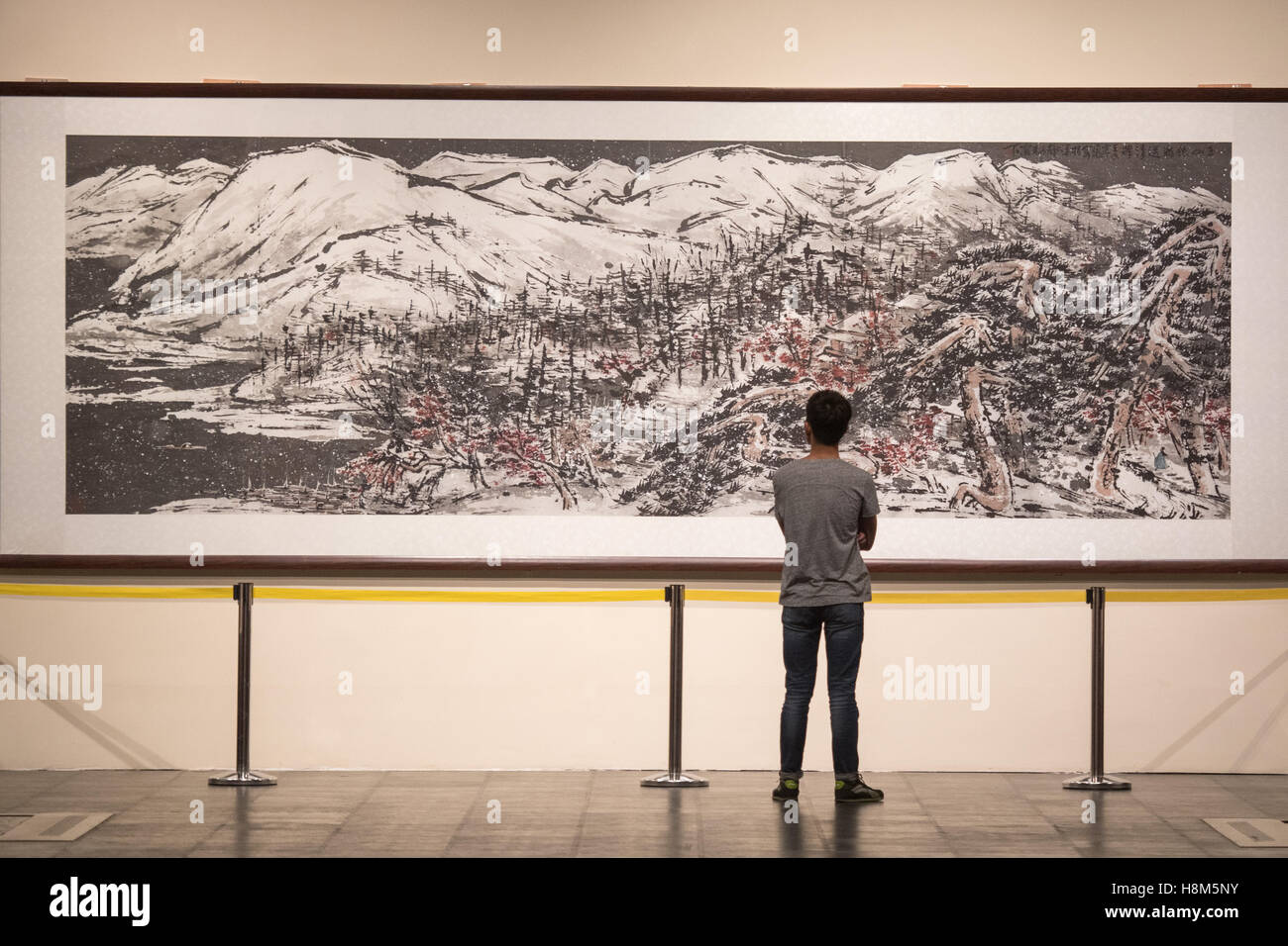 Peking-China - liegt Mann starrte auf ein altes Gemälde im Inneren das Palastmuseum in der verbotenen Stadt. Stockfoto
