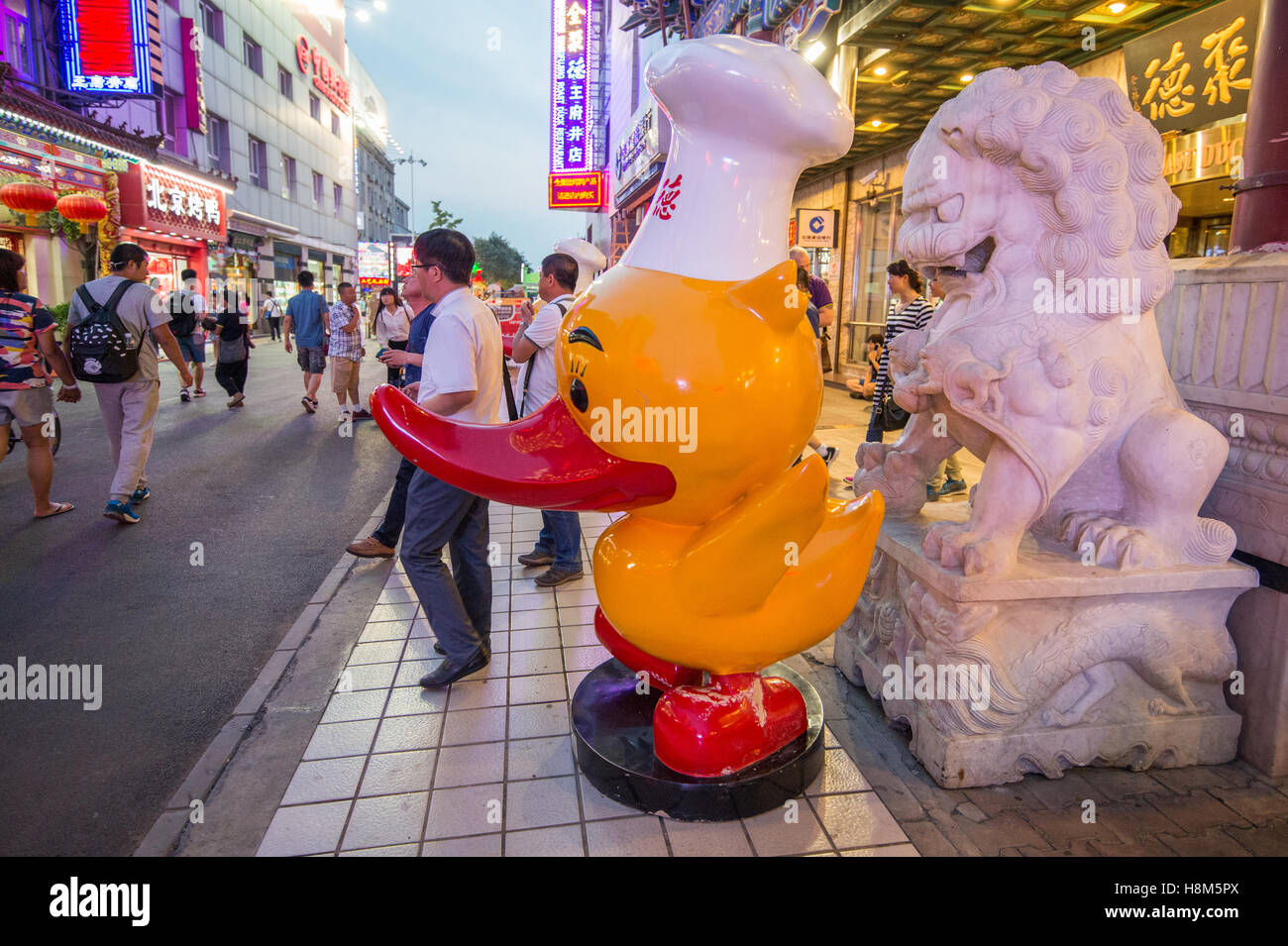 Peking - ein Foo-Hund und eine Statue einer Cartoon-Ente in der Donghuamen Snack Night Market, einem großen Outdoor-Markt d. h. eine Stockfoto