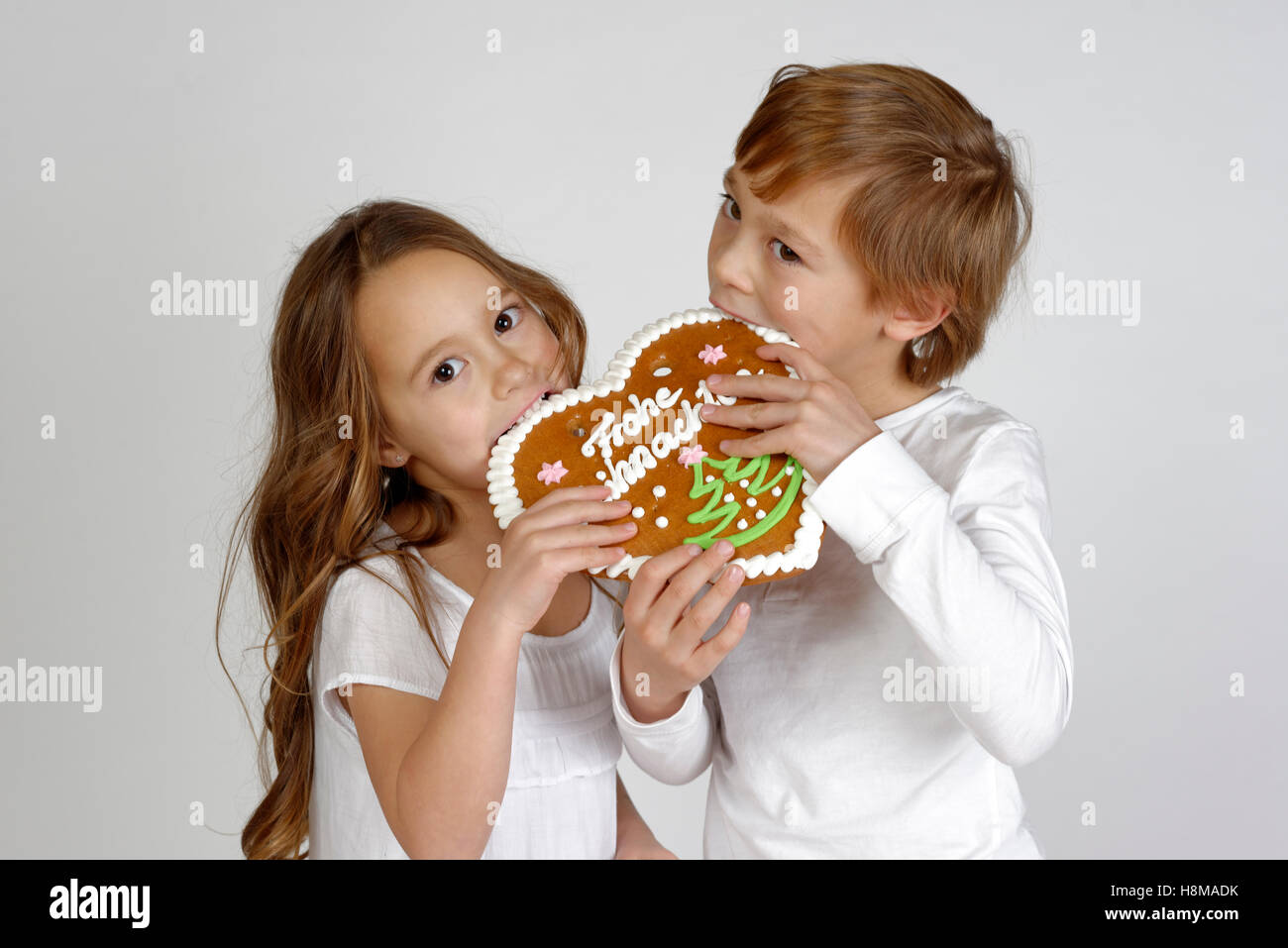 Kinder essen ein Lebkuchen Herz, Frohe Weihnachten, Weihnachtszeit, Deutschland Stockfoto