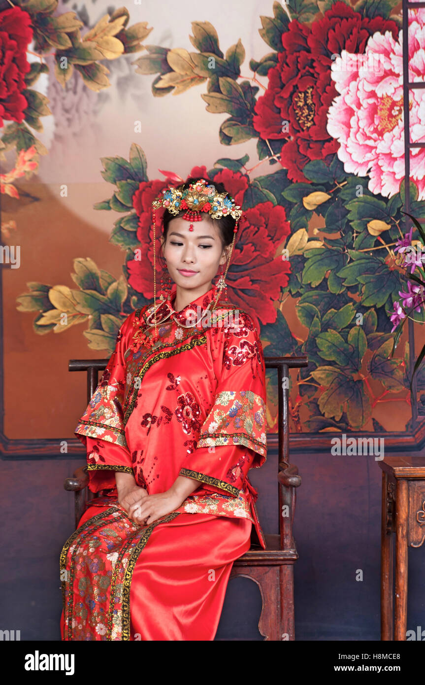 Asien / chinesisches Mädchen in traditionellen roten Kleid Stockfoto