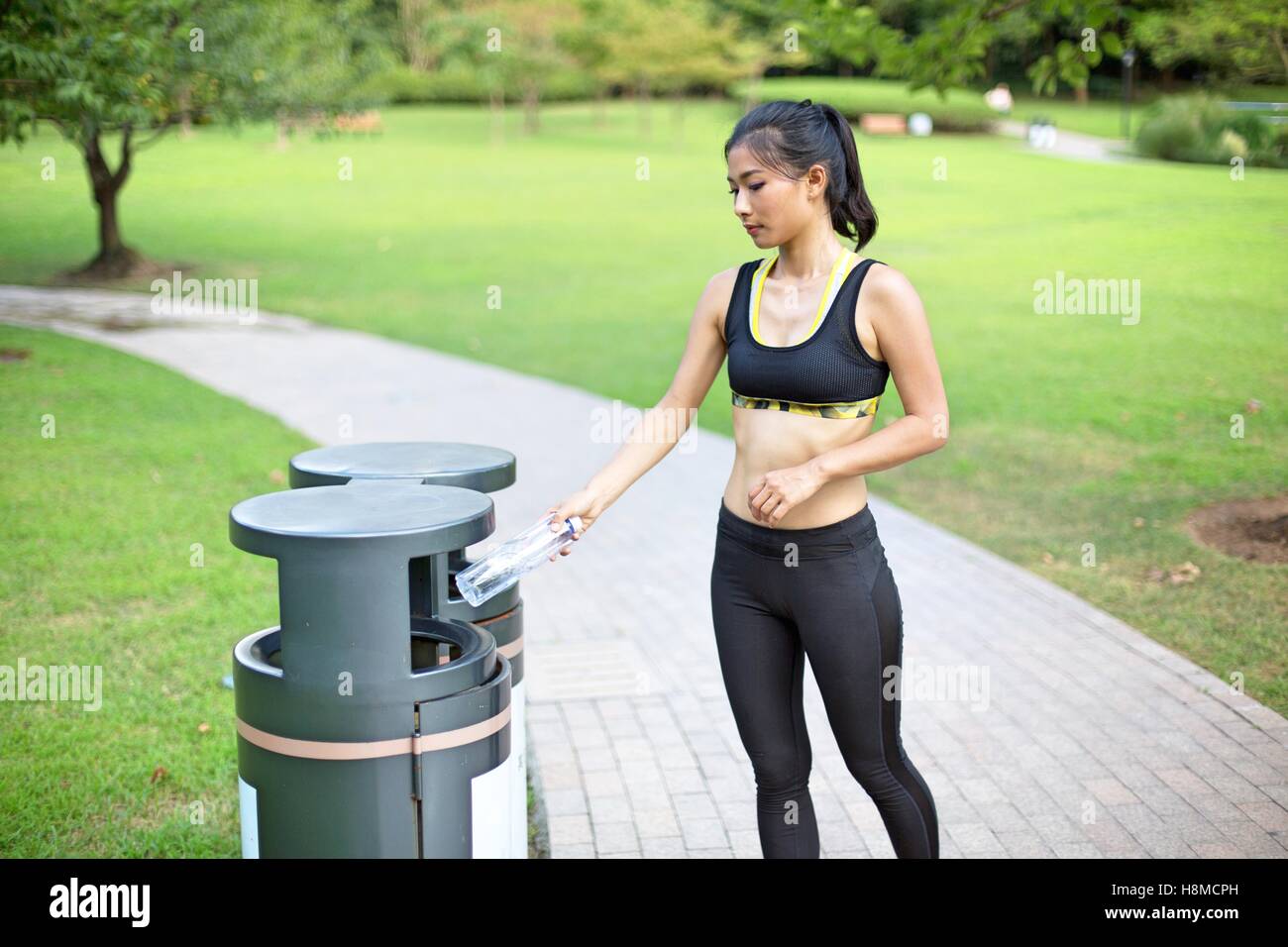 Schöne asiatische Frau recycling im Park nach ihrem Lauf Stockfoto