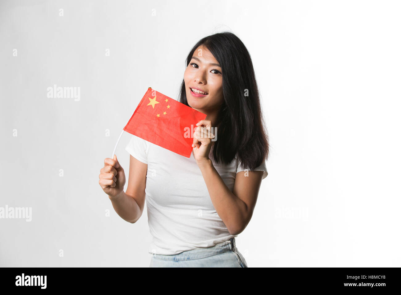 Chinesische Frau hält eine chinesische Flagge vor weißem Hintergrund Stockfoto