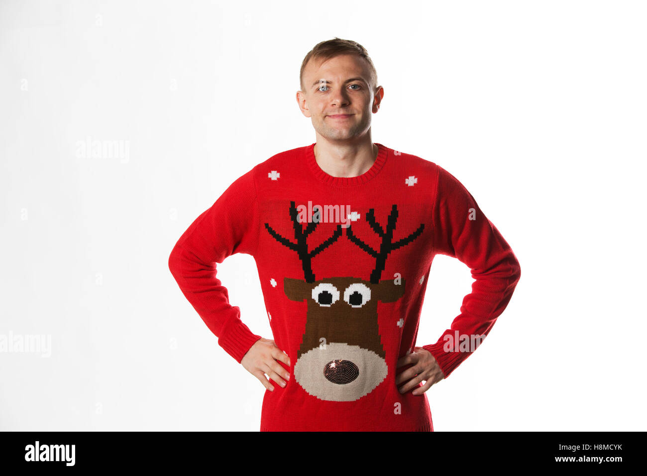 Kaukasischen Mann mit der Hand auf den Hüften, während ein Weihnachtspullover tragen Stockfoto