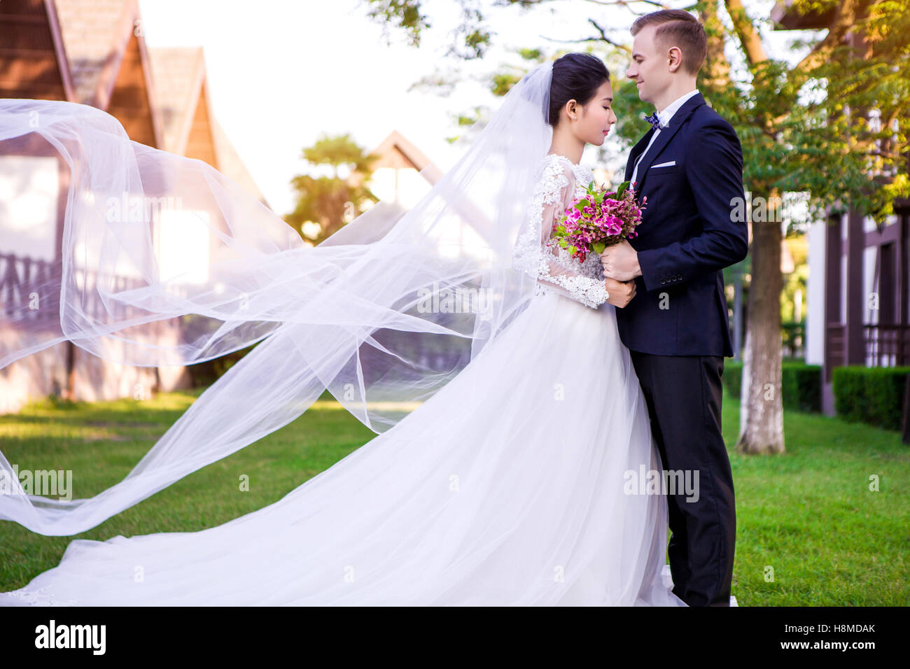 Seitenansicht des Hochzeitspaar stehend auf Rasen Stockfoto