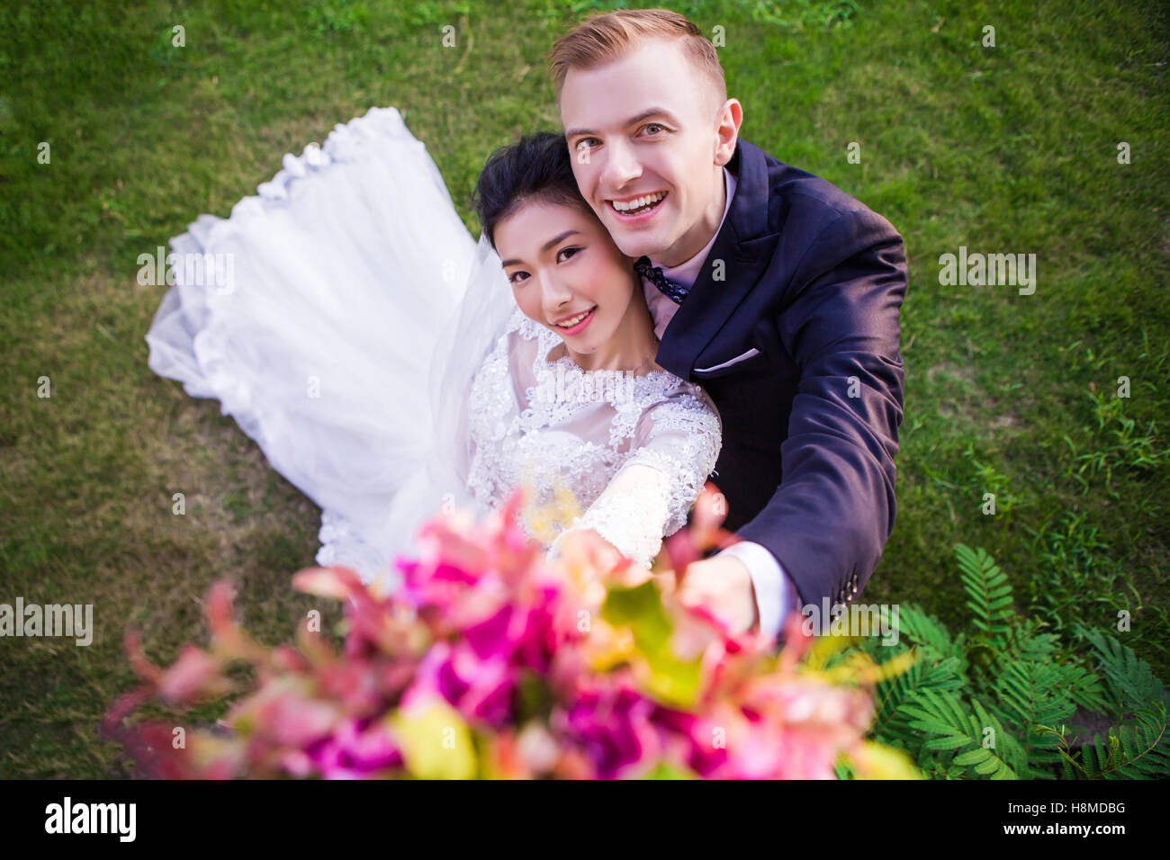 Hohen Winkel Bildniss glückliches Hochzeitspaar auf Wiese Stockfoto