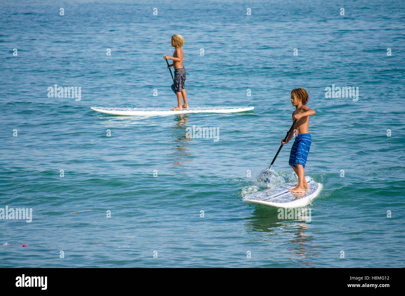 Zwei jungen paddle-boarding, Paddling, Mittelmeer, Spanien. Stockfoto
