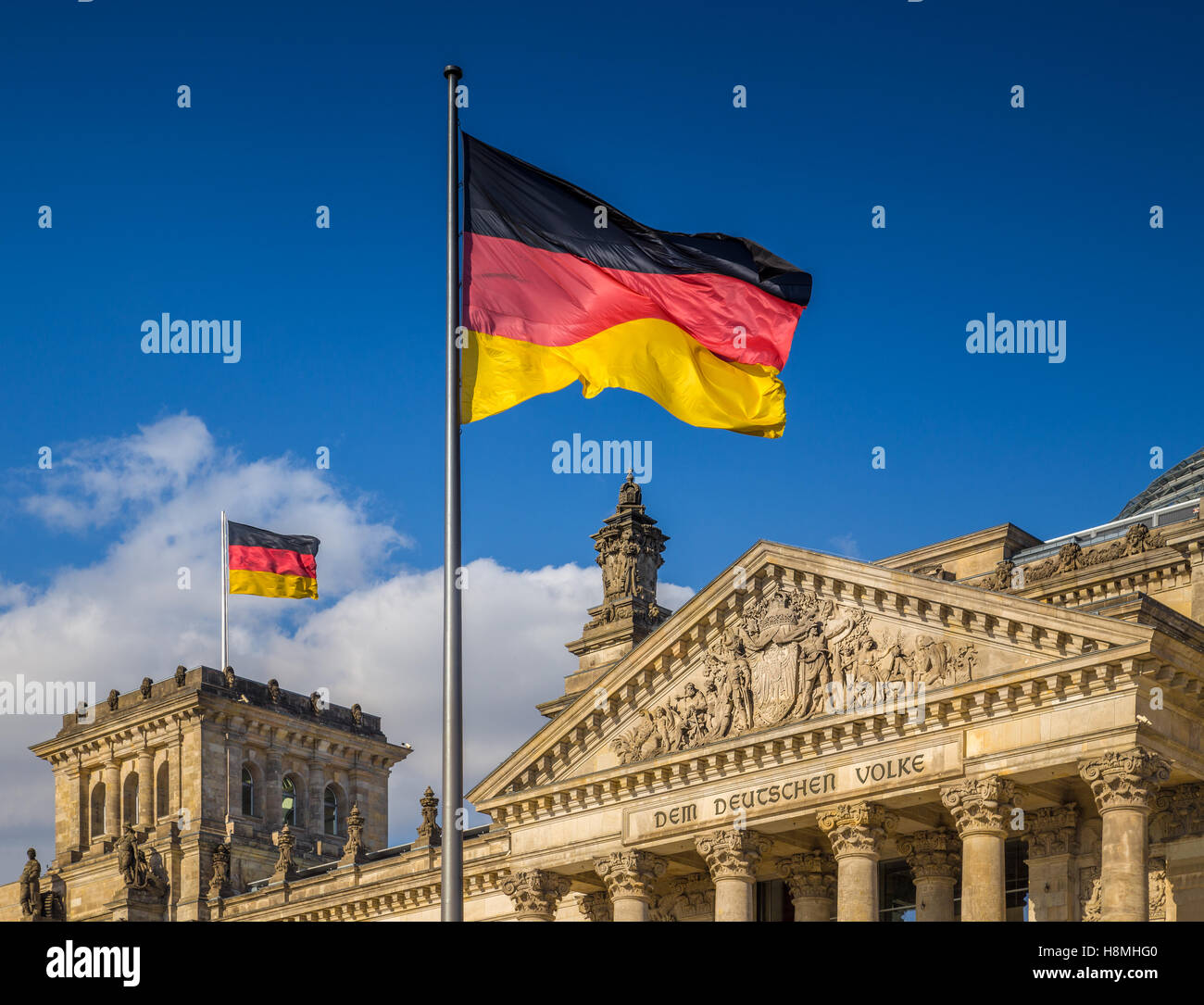 Deutsche Flaggen wehten im Wind am berühmten Reichstagsgebäude, Sitz des Deutschen Bundestages, an einem sonnigen Tag in Berlin, Deutschland Stockfoto