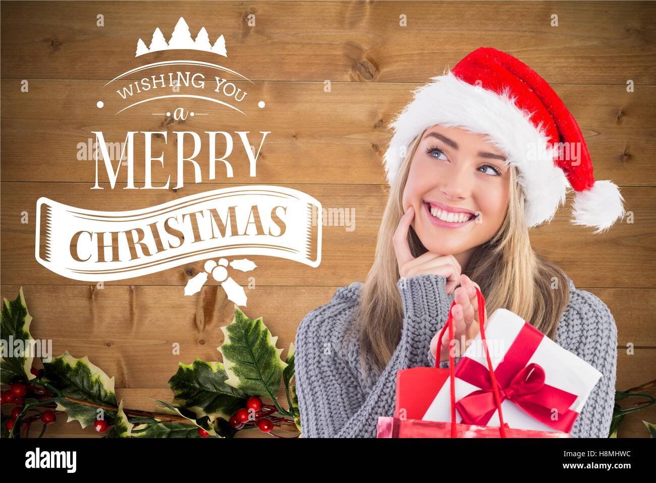 Nachdenkliche Frau hält Weihnachtsgeschenke lächelnd Stockfoto