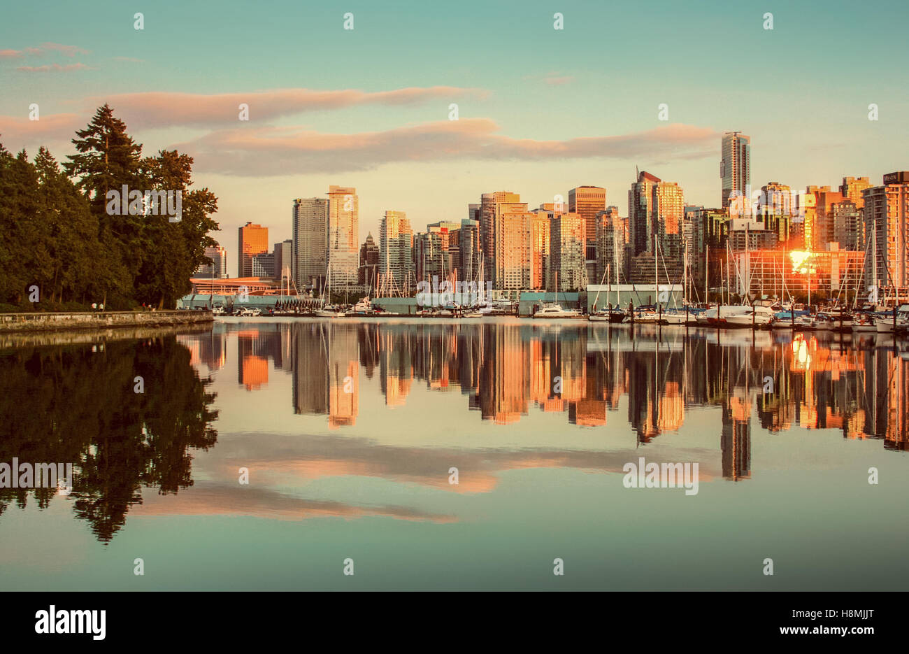 Klassische Ansicht der Skyline von Vancouver mit Stanley Park reflektiert in ruhigem Wasser bei Sonnenuntergang, Britisch-Kolumbien, Kanada Stockfoto