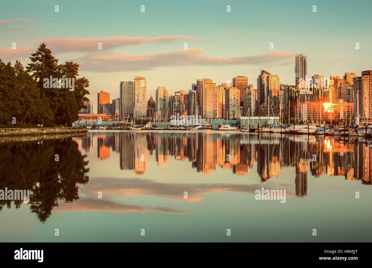 Klassische Ansicht der Skyline von Vancouver mit Stanley Park reflektiert in ruhigem Wasser bei Sonnenuntergang, Britisch-Kolumbien, Kanada Stockfoto Klassische Ansicht der Skyline von Vancouver mit Stanley Park reflektiert in ruhigem Wasser bei Sonnenuntergang, Britisch-Kolumbien, Kanada Stockfoto