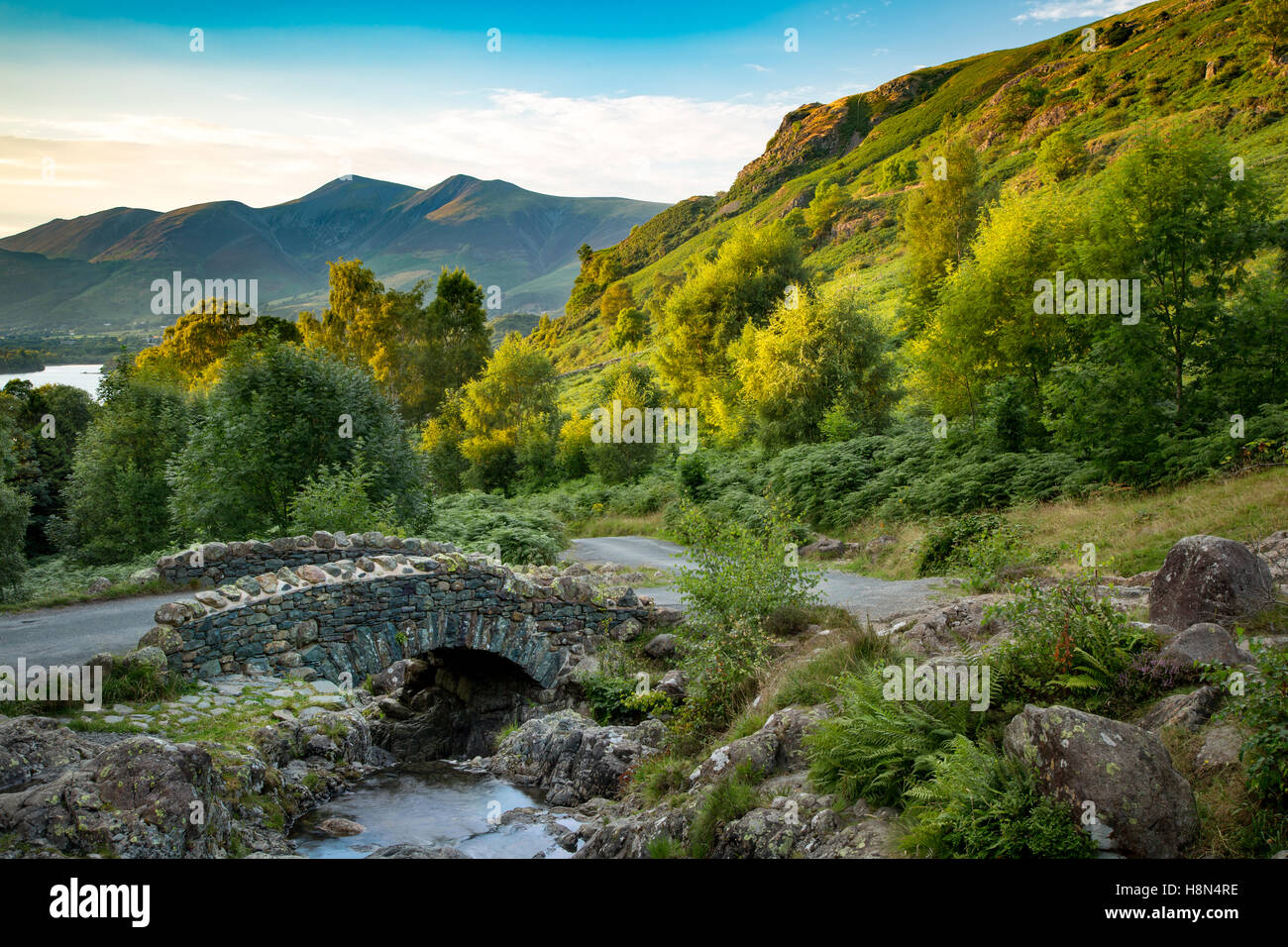 Ashness Brücke und die letzten Sonnenstrahlen auf den Bergen oberhalb von Derwentwater, Lake District, Cumbria, England Stockfoto