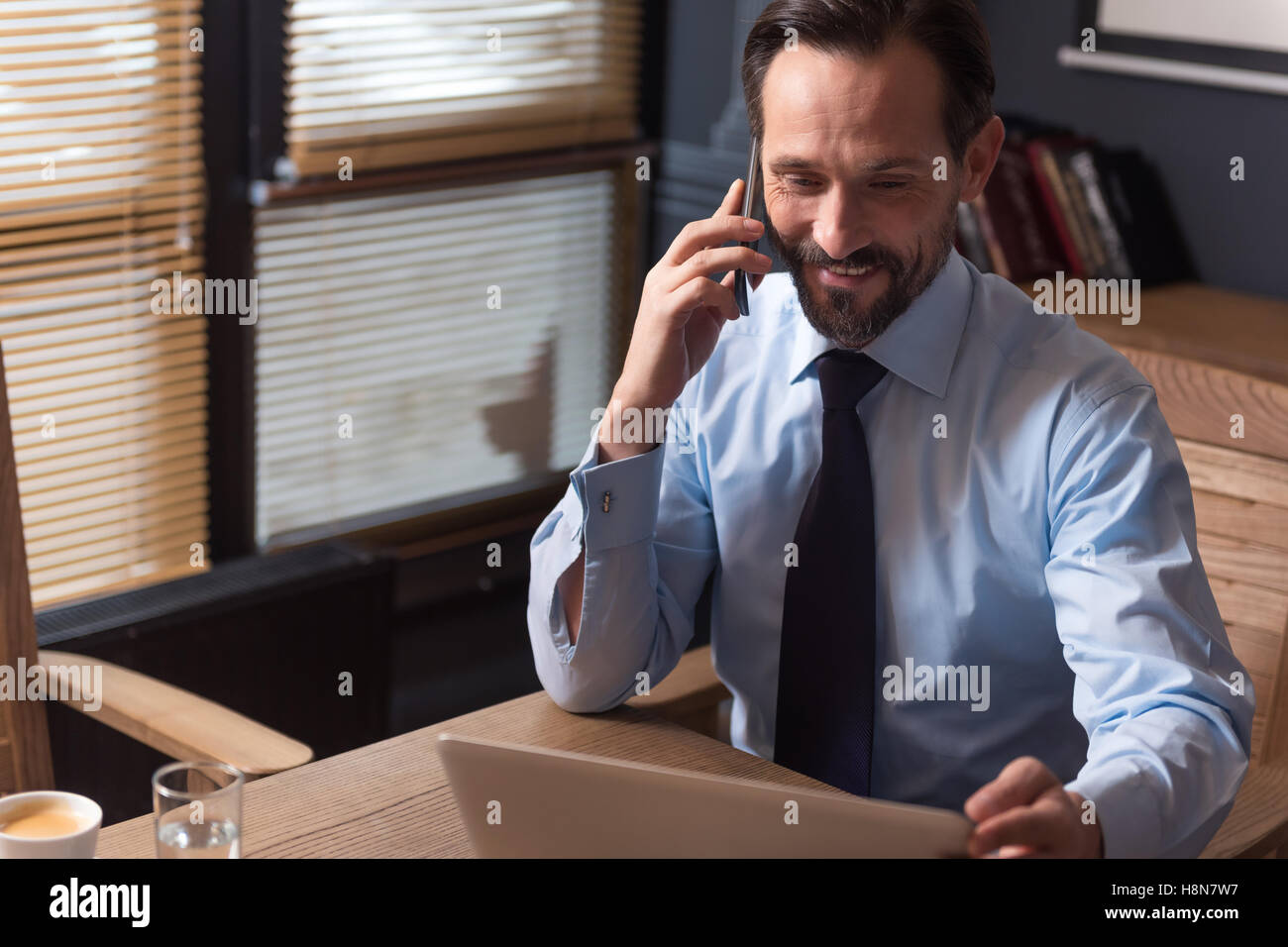 Angenehm hart arbeiten-Manager mit einem Telefongespräch Stockfoto