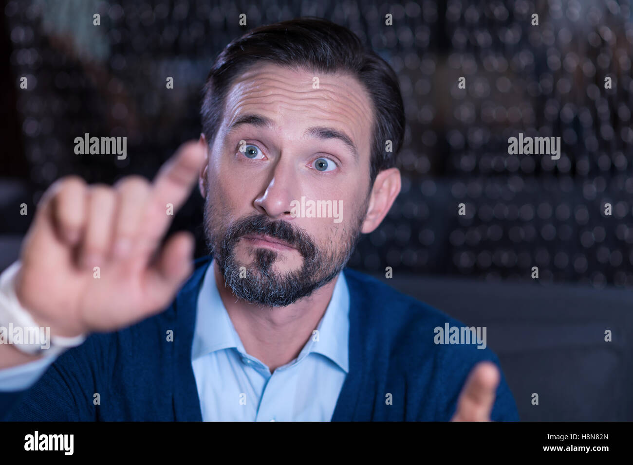 Neugierig gut aussehender Mann berühren des virtuellen Bildschirms mit dem finger Stockfoto