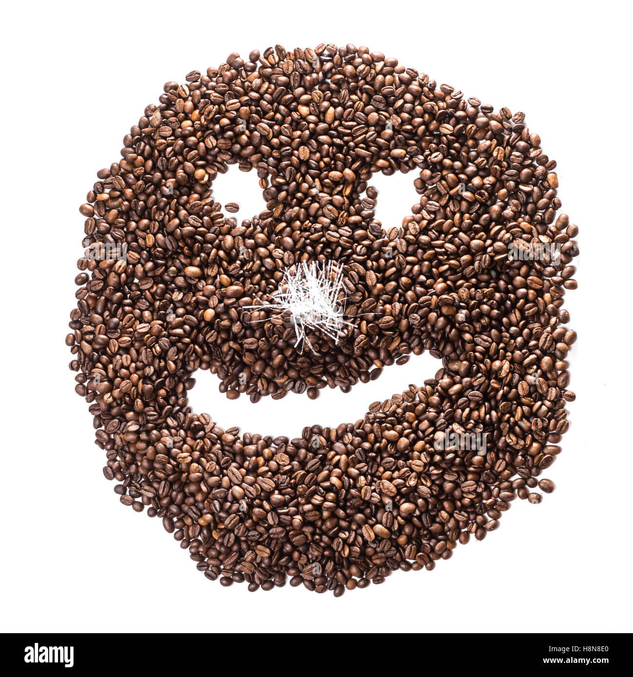 Lustige Smiley Kaffeebohnen mit einer Nase aus Lametta isoliert auf weißem Hintergrund Stockfoto