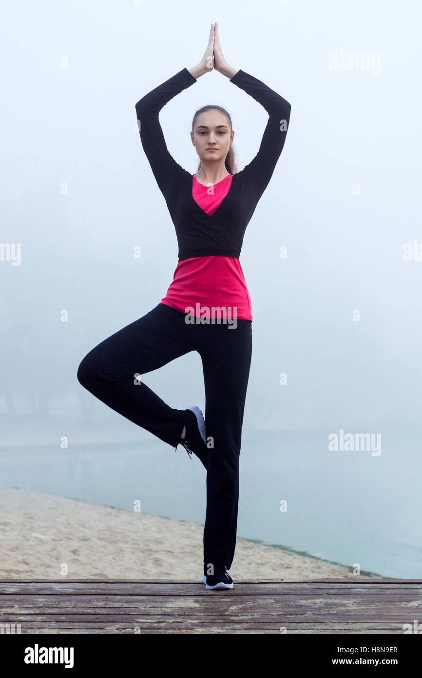 Junge ziemlich schlank Fitness sportliche Frau tut Yoga-Übungen beim Training Training im freien Stockfoto