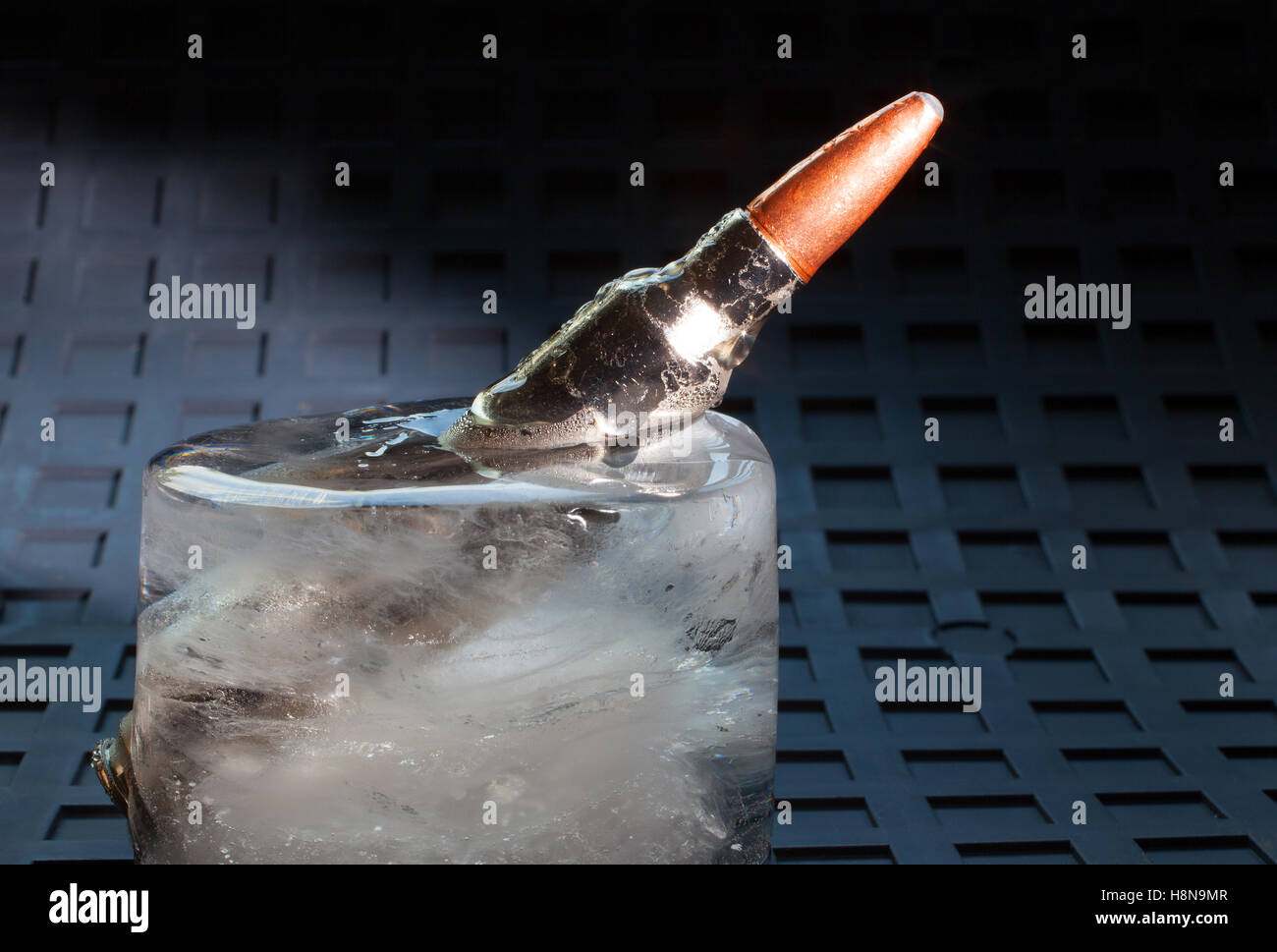 Patrone, die gefroren ist in einem großen Eisblock Stockfoto