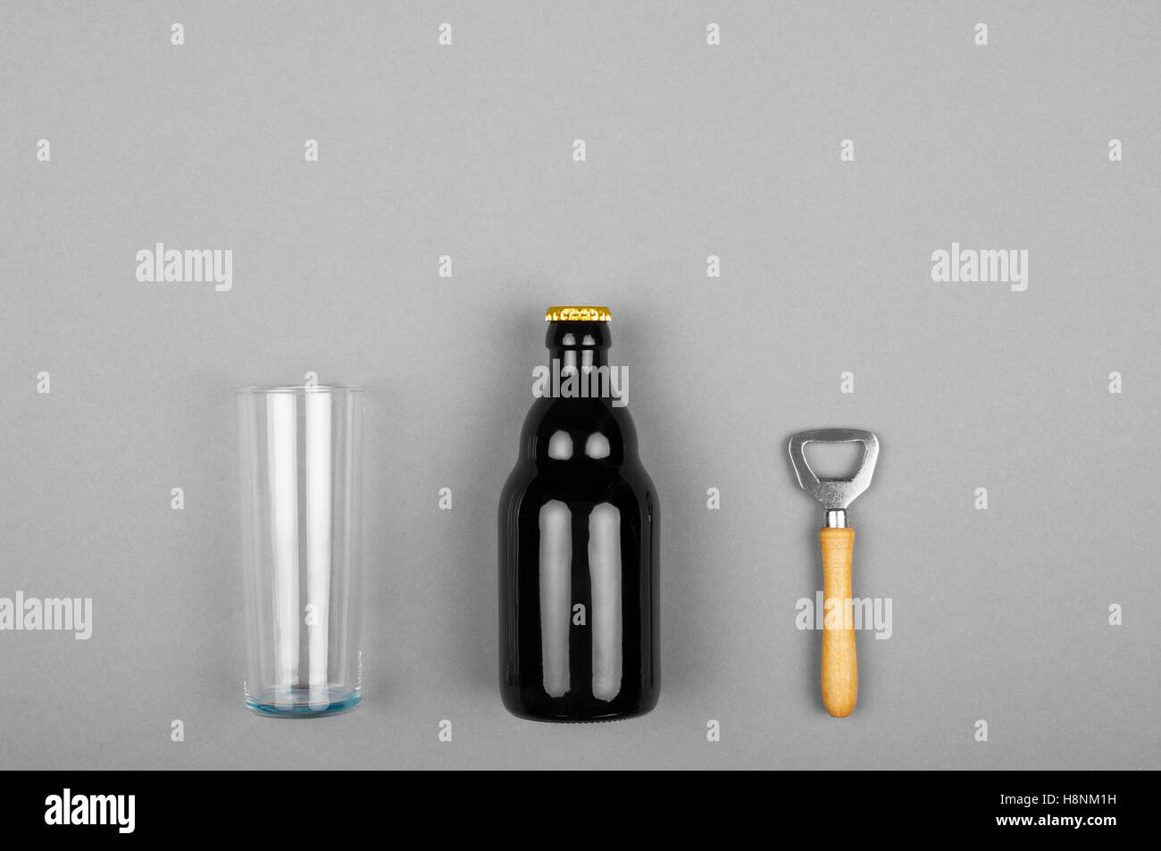 Eine Flaschenbier, ein Flaschenöffner mit Holzgriff und einem Bierglas Stockfoto