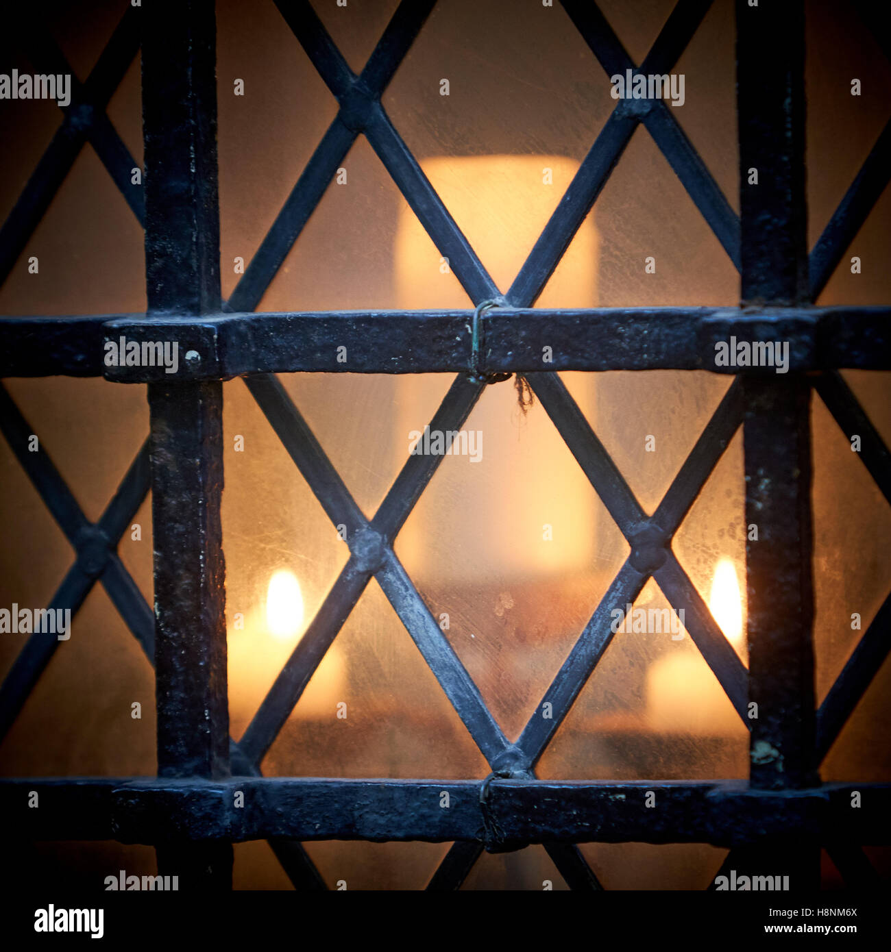 Kerzen brennen hinter altmodische Bleiglasfenster Stockfoto