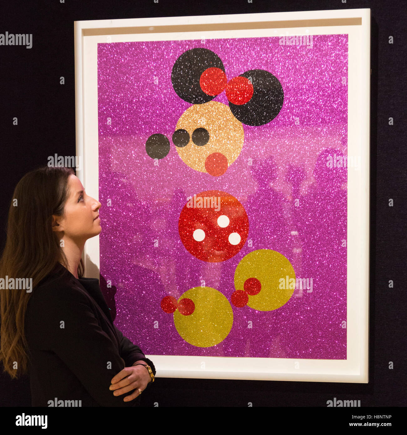 London, UK. 14. November 2016. Ein Mitarbeiter von Bonhams schaut Minnie (Rosa Glitter) von Damien Hirst, ca. 8.000-12.000. GBP-Vorschau für Bonhams anstehenden Drucke & Multiples Verkäufe am 16. November. Das Line-up umfasst Werke von Künstlern wie Lichtenstein, Warhol, Hockney und Hirst. Stockfoto