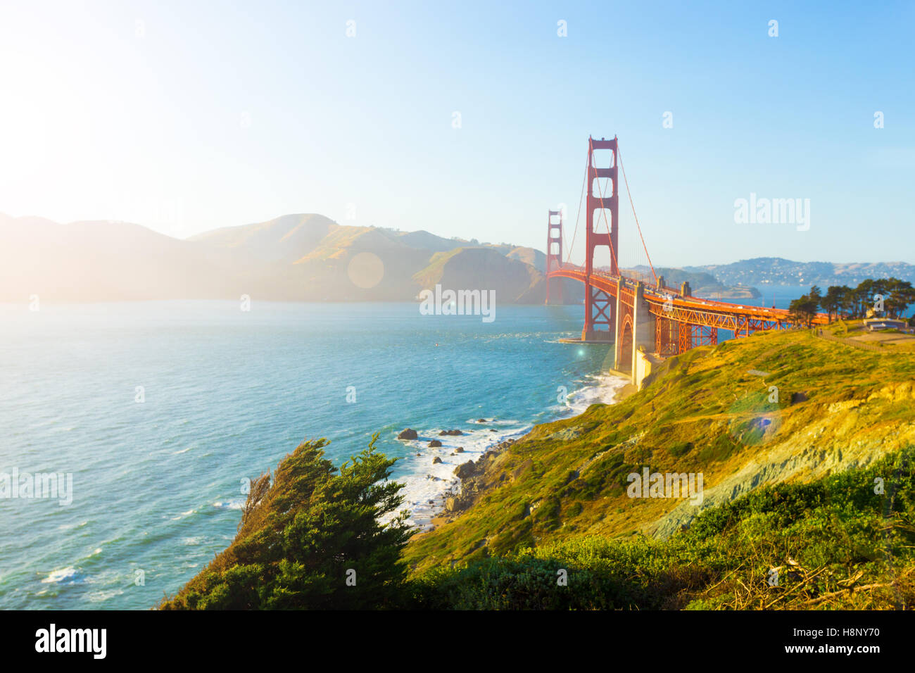 Sonnenlicht sorgt hoch wichtigen Highlights, Reflexlicht über Marin Headlands mit Golden Gate Bridge über felsige Küste gesehen Stockfoto
