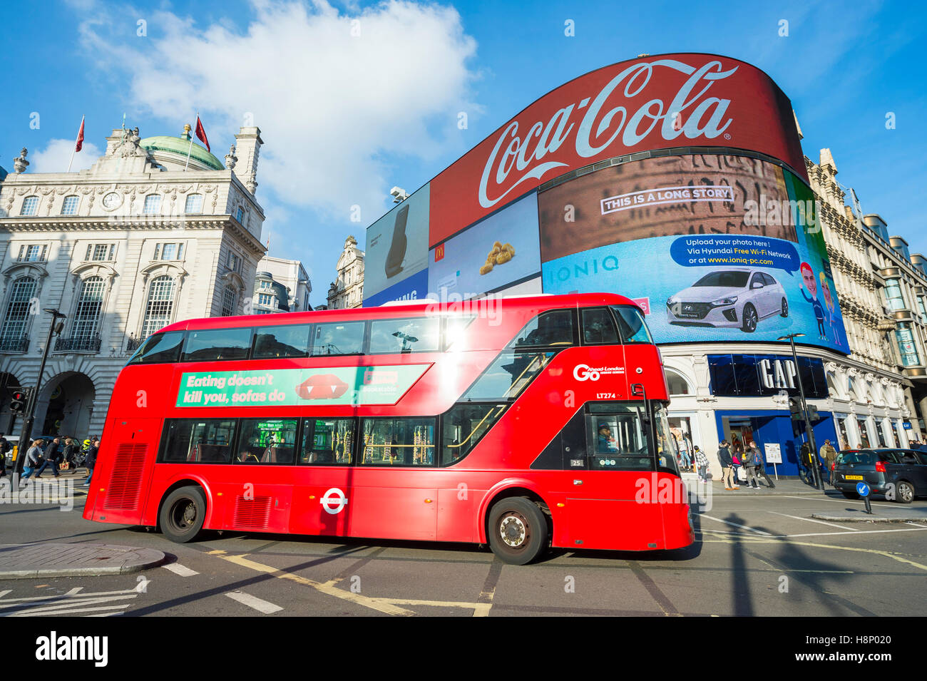 LONDON - 11. November 2016: Moderne Doppeldecker Bus Pässe durch die blinkende Zeichen des Piccadilly Circus an einem hellen Morgen. Stockfoto