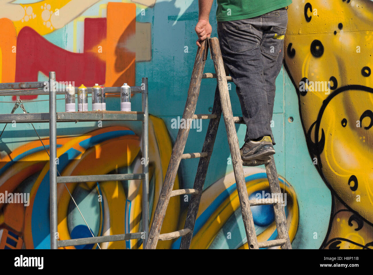 Maler auf Leiter Gemälde ein Graffiti an der Wand Stockfoto