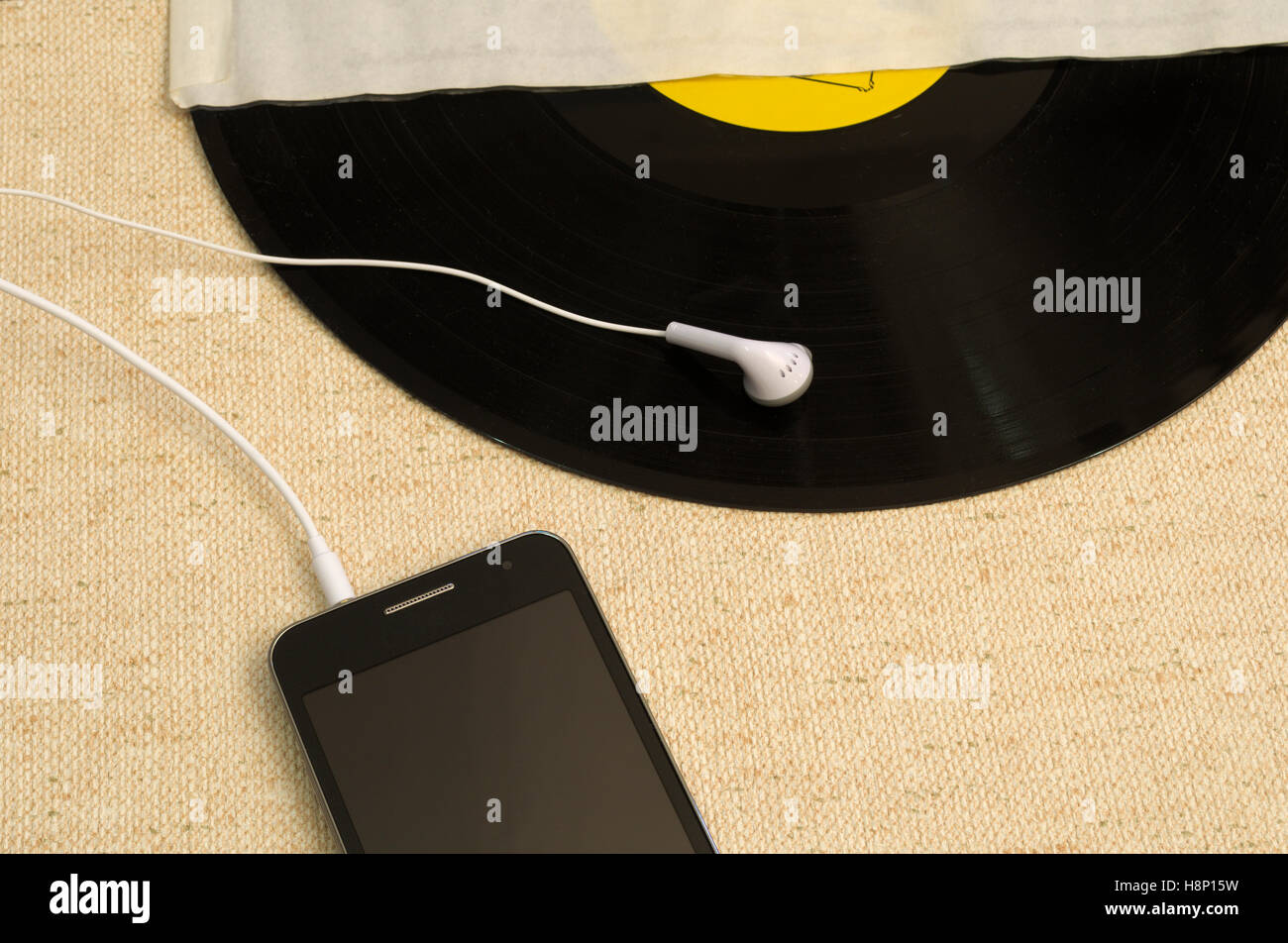 Smartphone mit Ohrhörer und LP Stockfoto