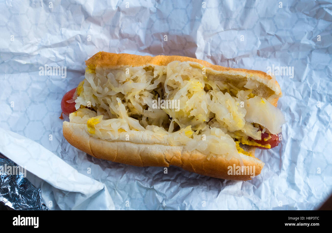 Hot Dog mit gelbem Senf und Sauerkraut auf einer Rolle Stockfoto
