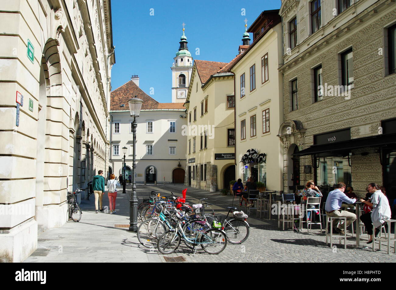 Ljubljana, Slowenien, 25. September 2016: Stadtzentrum, Altstädter Ring. Viele Fahrrad-Stände auf der Straße, Menschen sitzen in den Gastgarten. Stockfoto