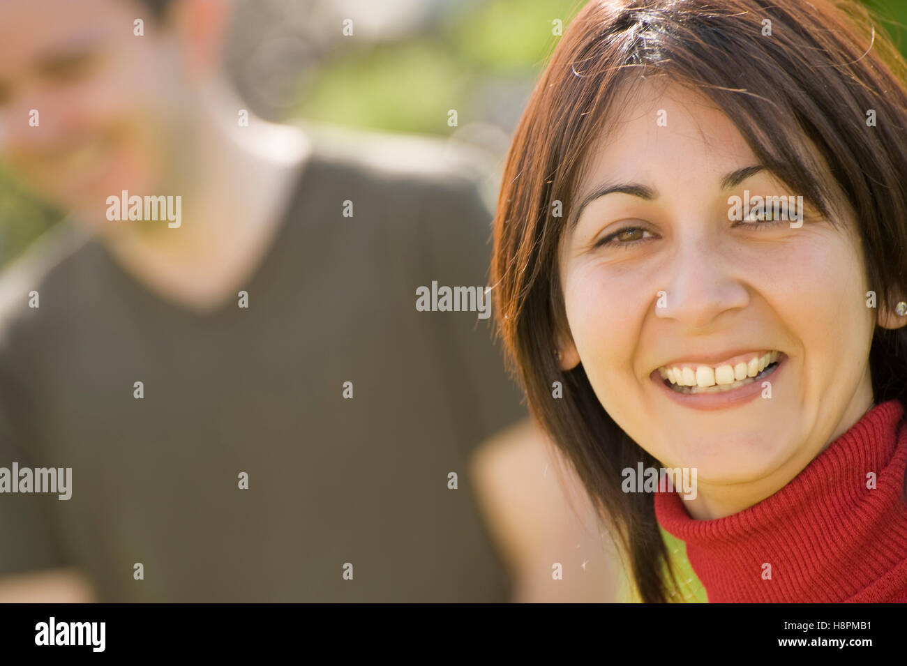 Frau, 30, Mann im Hintergrund unscharf Stockfoto