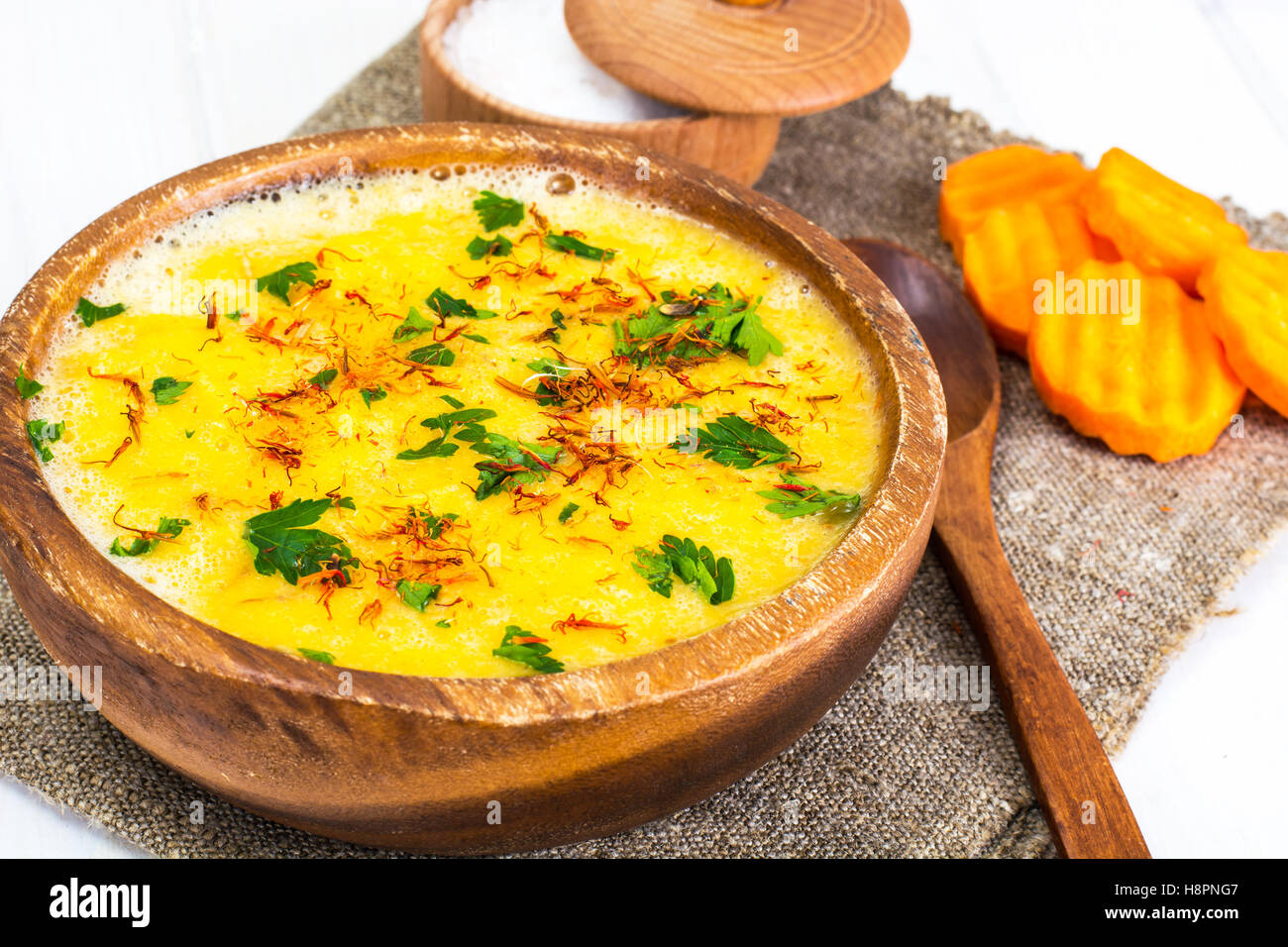 Kürbis Cremesuppe mit Safran und Petersilie in einer Holzschale Stockfoto