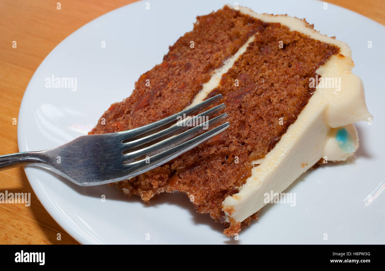 Gabel und Karotte-Kuchen-Scheibe auf einem weißen Teller Stockfoto