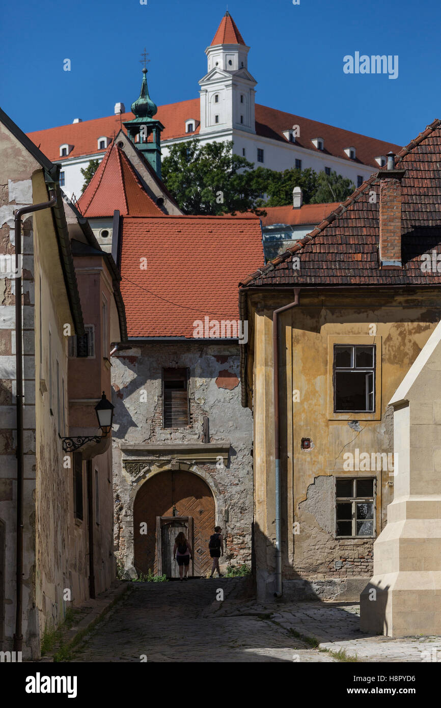 Touristen erkunden die Seitenstraßen und bröckelnden Altbauten von Bratislava in der Slowakei in Osteuropa. Bratislava ist der pol Stockfoto