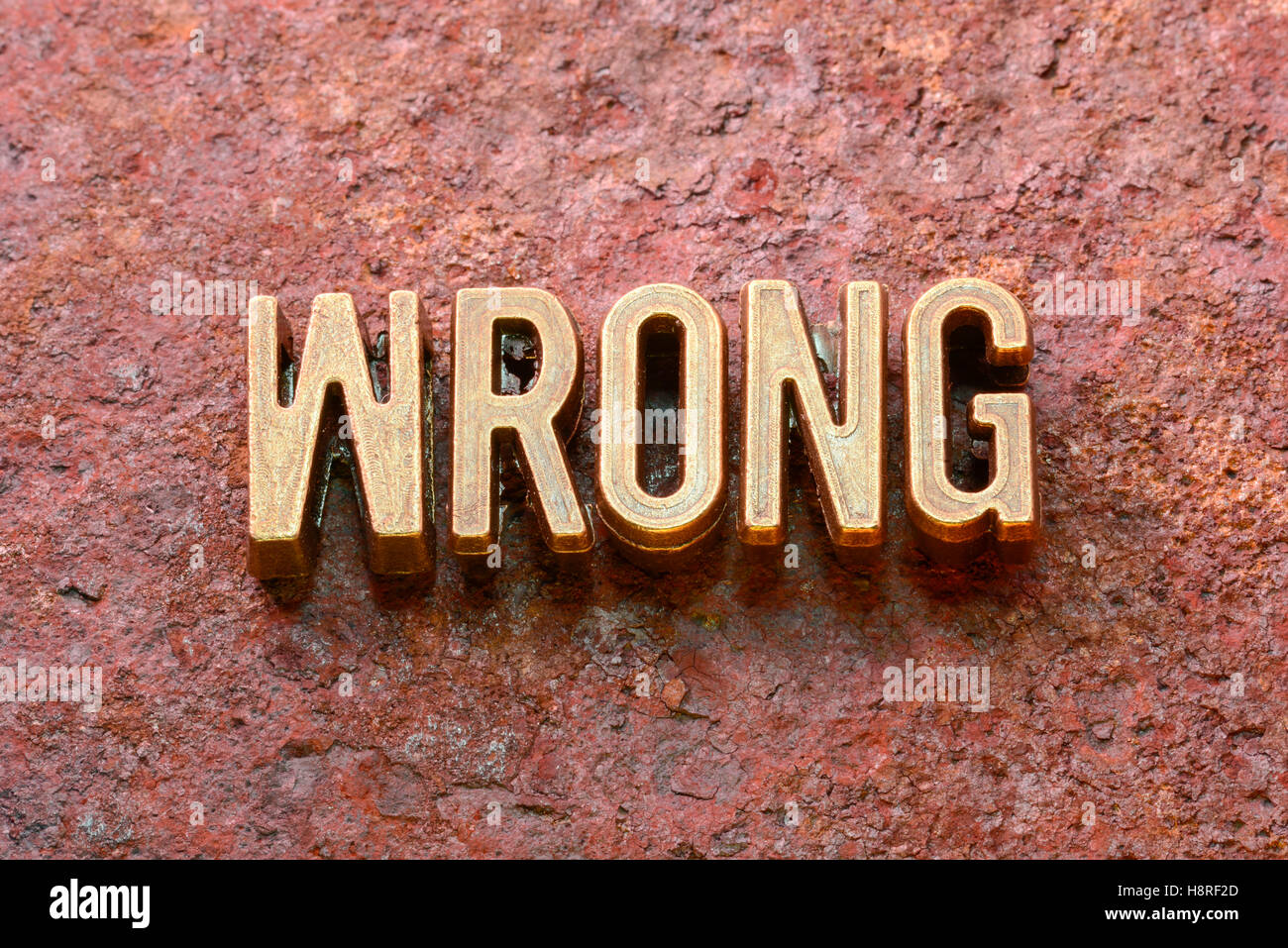 falsches Wort aus metallischen Lettern auf rotem rostige Oberfläche hergestellt Stockfoto