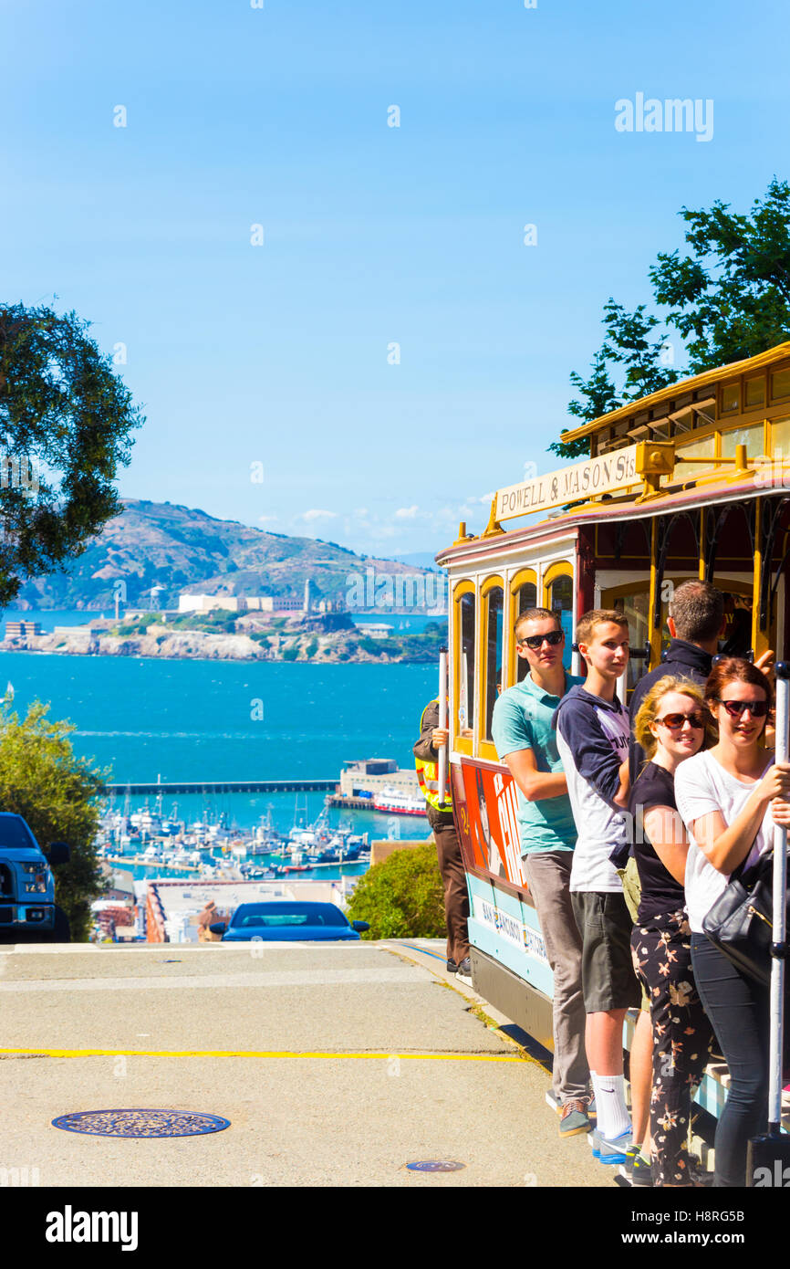 Nahaufnahme der Fahrgäste stehend auf externe Plattform hängen an Handläufe der berühmten Seilbahn mit Blick auf Alcatraz Stockfoto